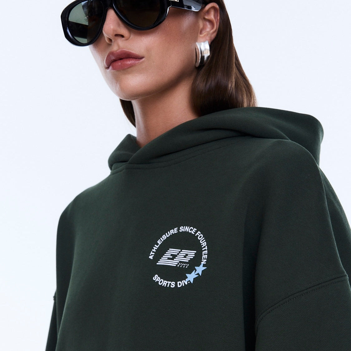 Close-up of moss green Aries Hoodie showing chest emblem and hood detail