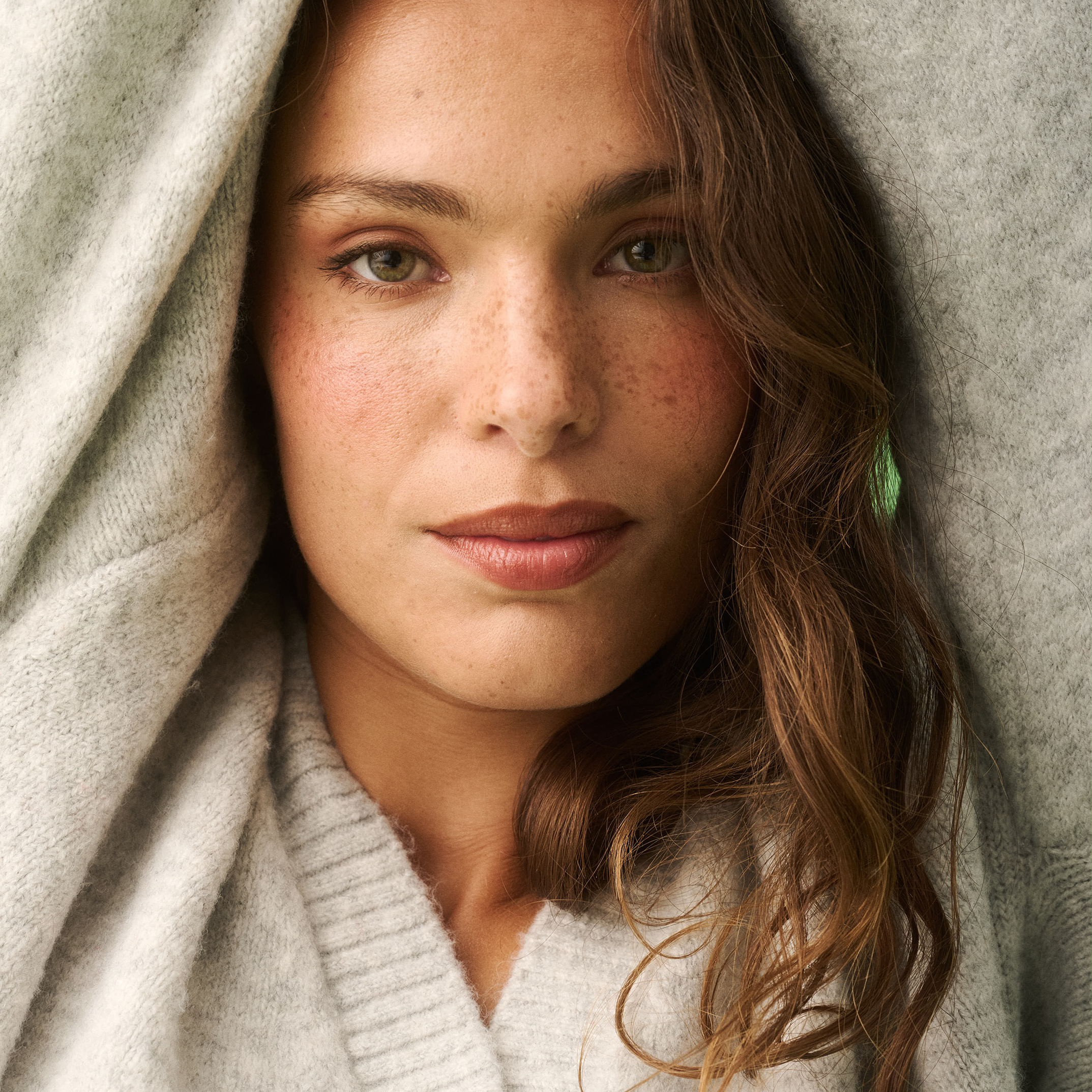 Close-up of grey marle knit cardigan showing ribbed collar and cream button detail