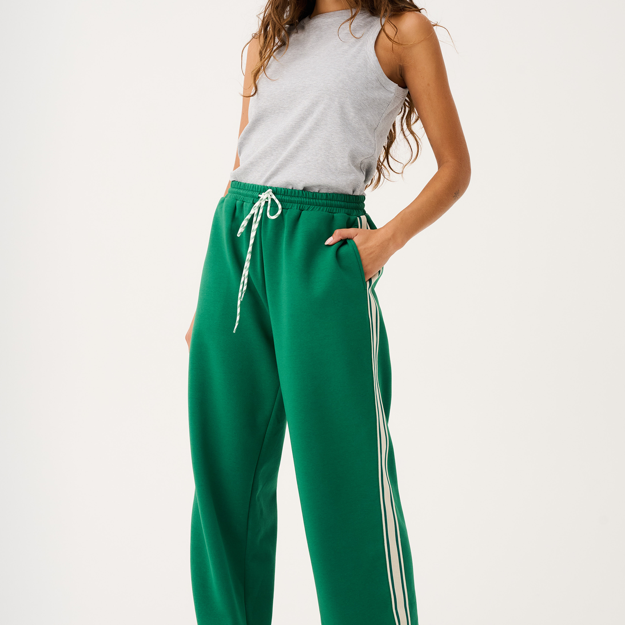 Front view of green Adeline Pants with white side stripes and drawstring waist in tide colorway