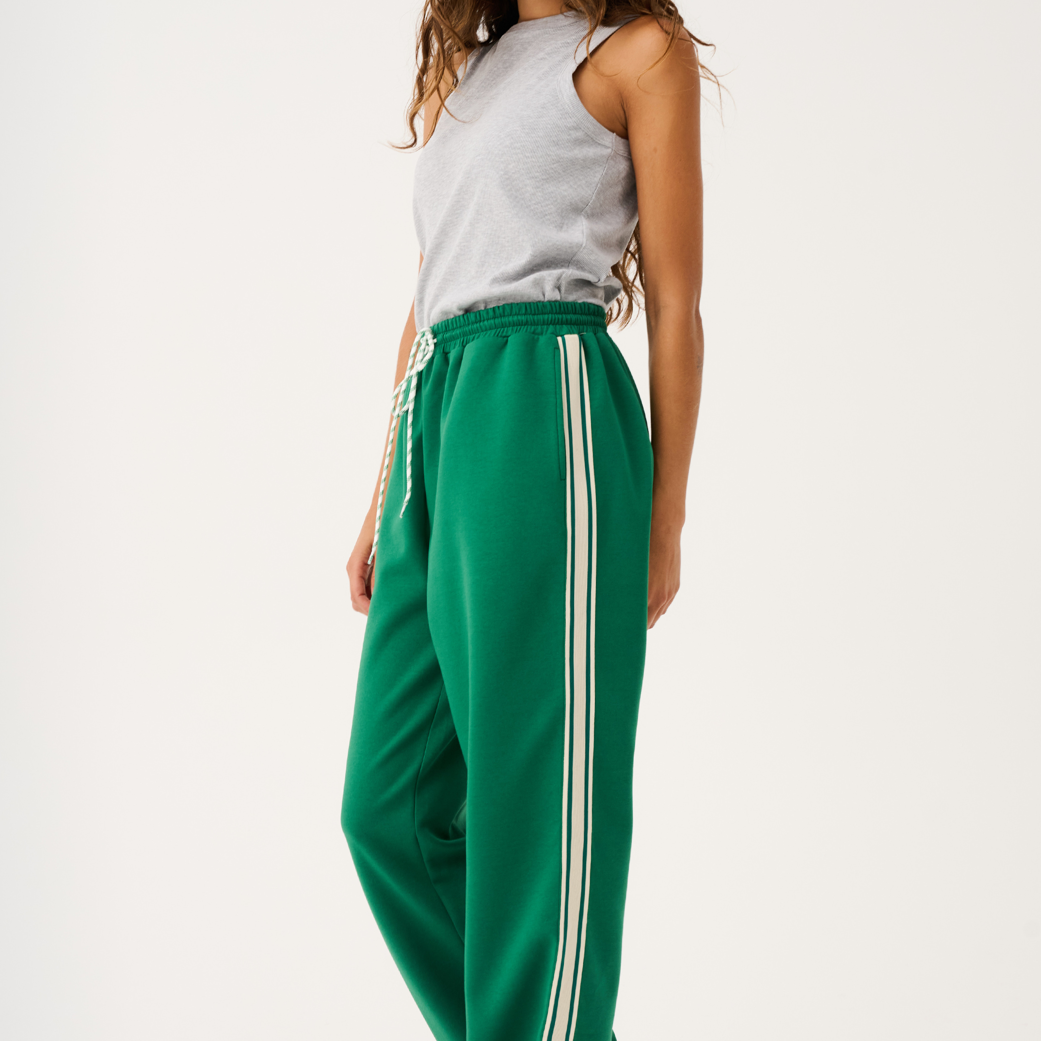 Three-quarter view of Adeline Pants showing relaxed wide-leg fit and athletic stripe trim