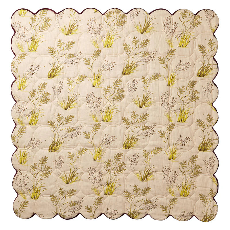 quilt with cream background and floral print in green and yellow with Scalloped edges. By Sage & Clare
