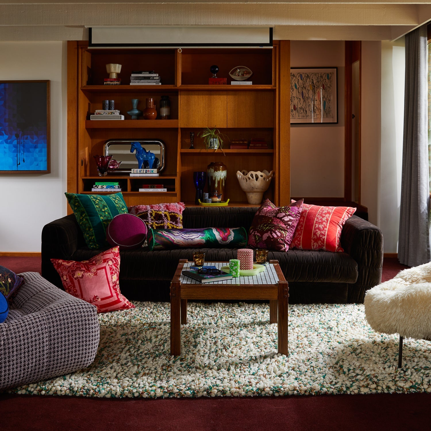 Wide angle view of Agata Velvet Cushion in modern living room interior with built-in shelving