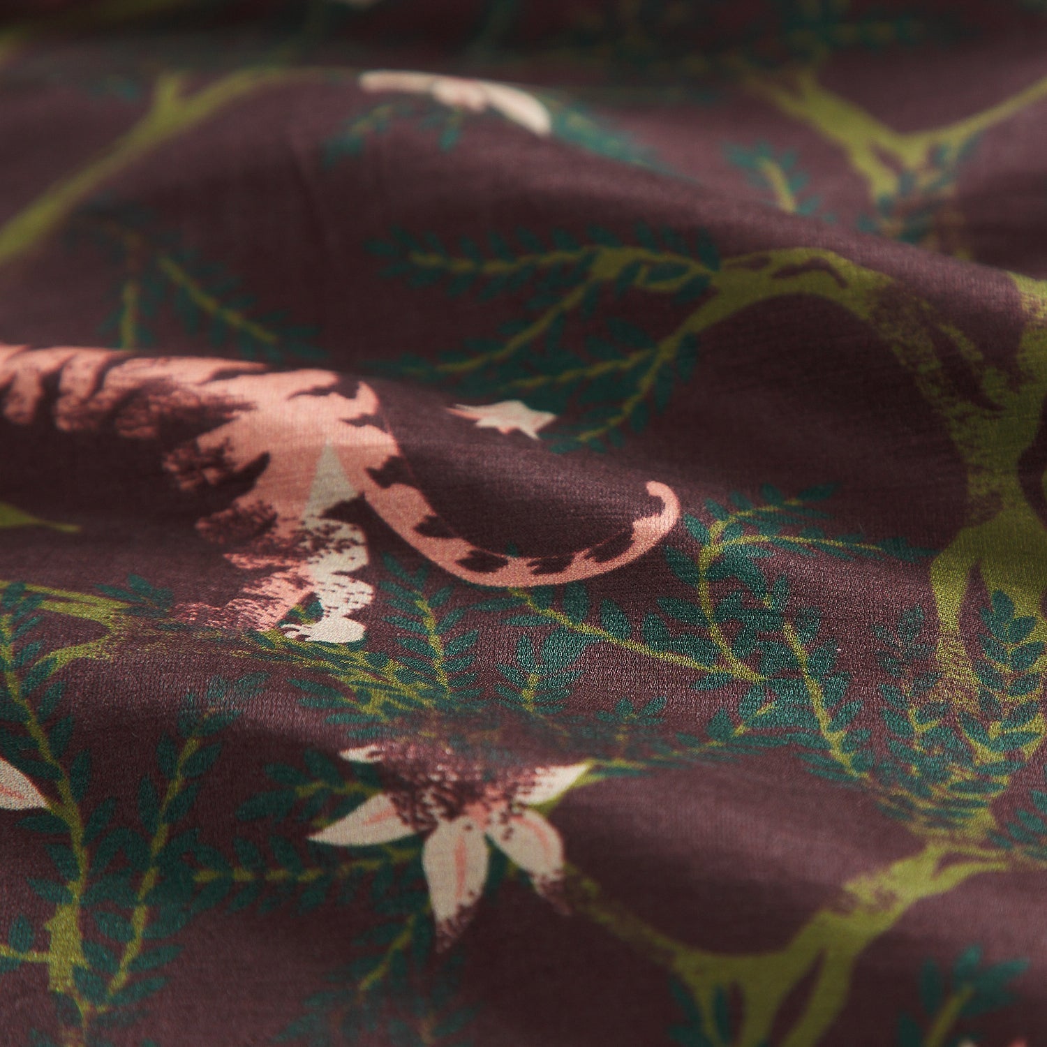 Extreme close-up of linen silk blend fabric texture showing tigers and foliage pattern detail on rosewood base