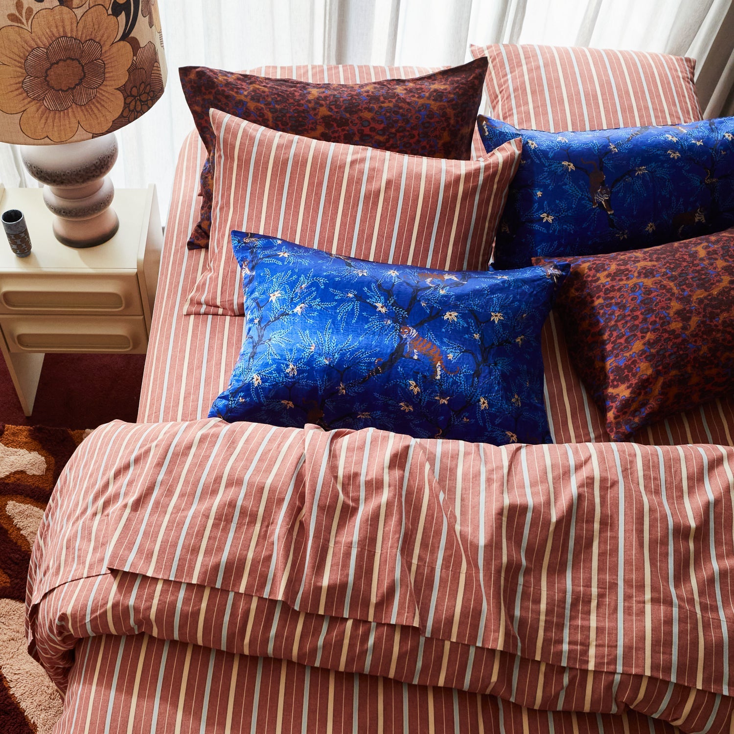 Ultramarine pillowcase styled with striped and patterned bedding in modern bedroom setting