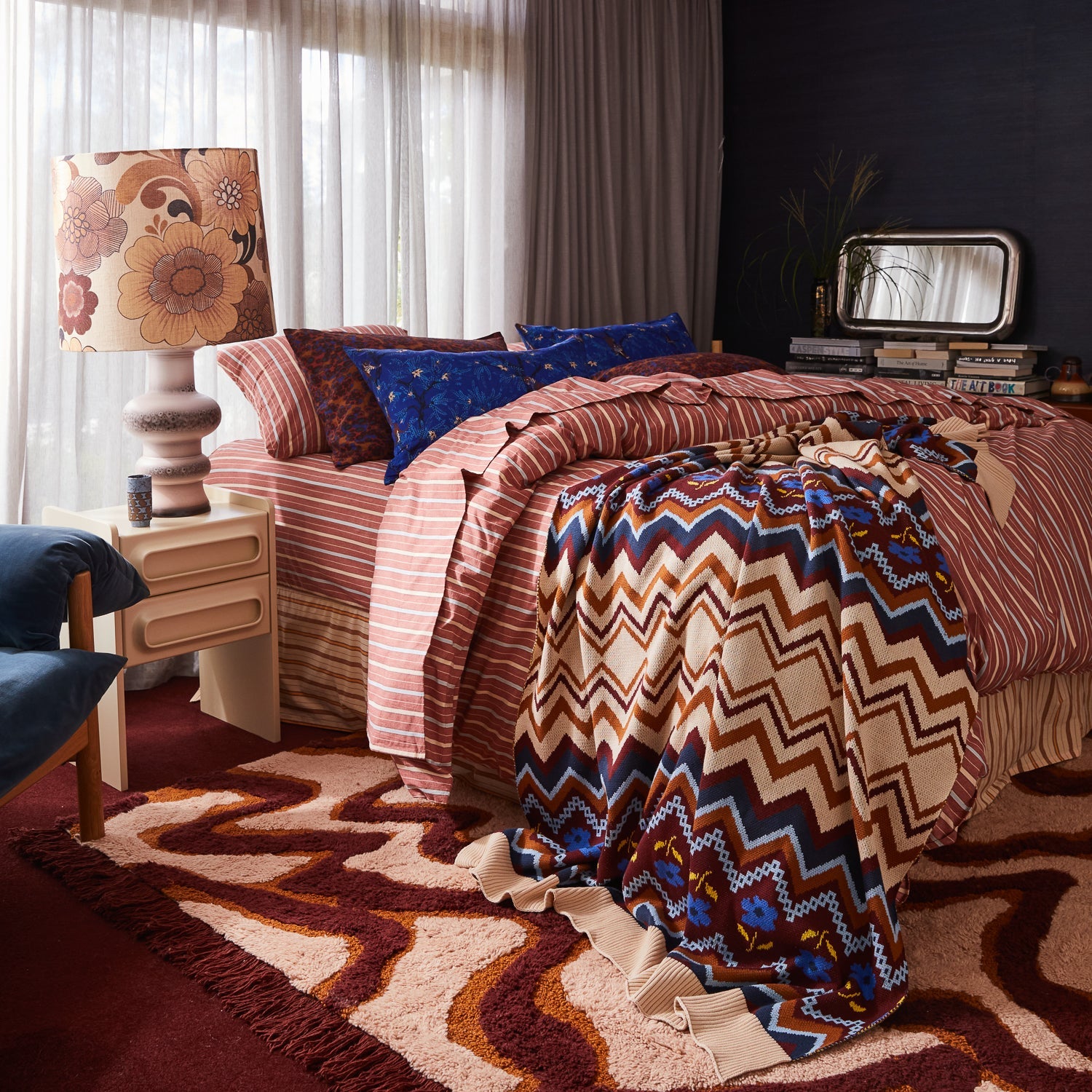 Bedroom styling featuring Andrea pillowcase mixed with striped sheets and geometric throw