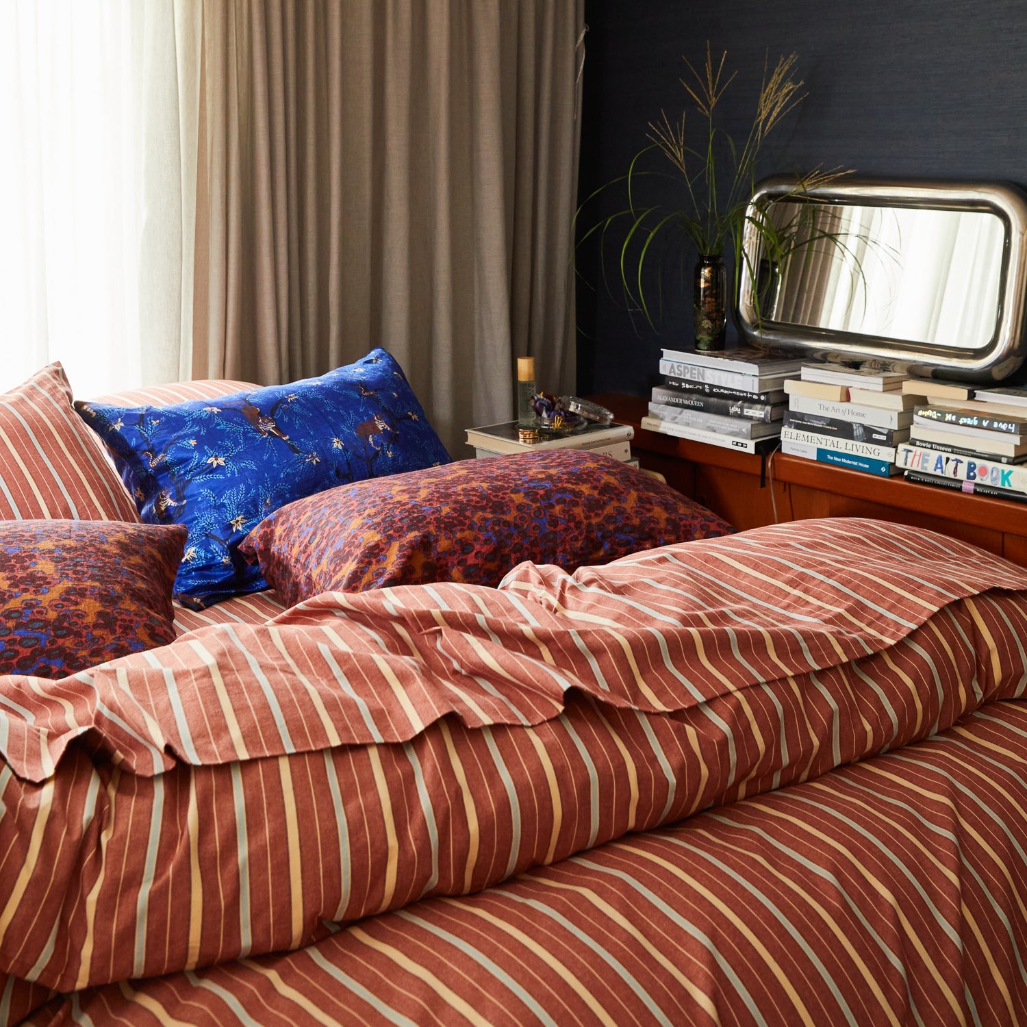 Modern bedroom scene with ultramarine linen-silk pillowcase among colorful patterned bedding