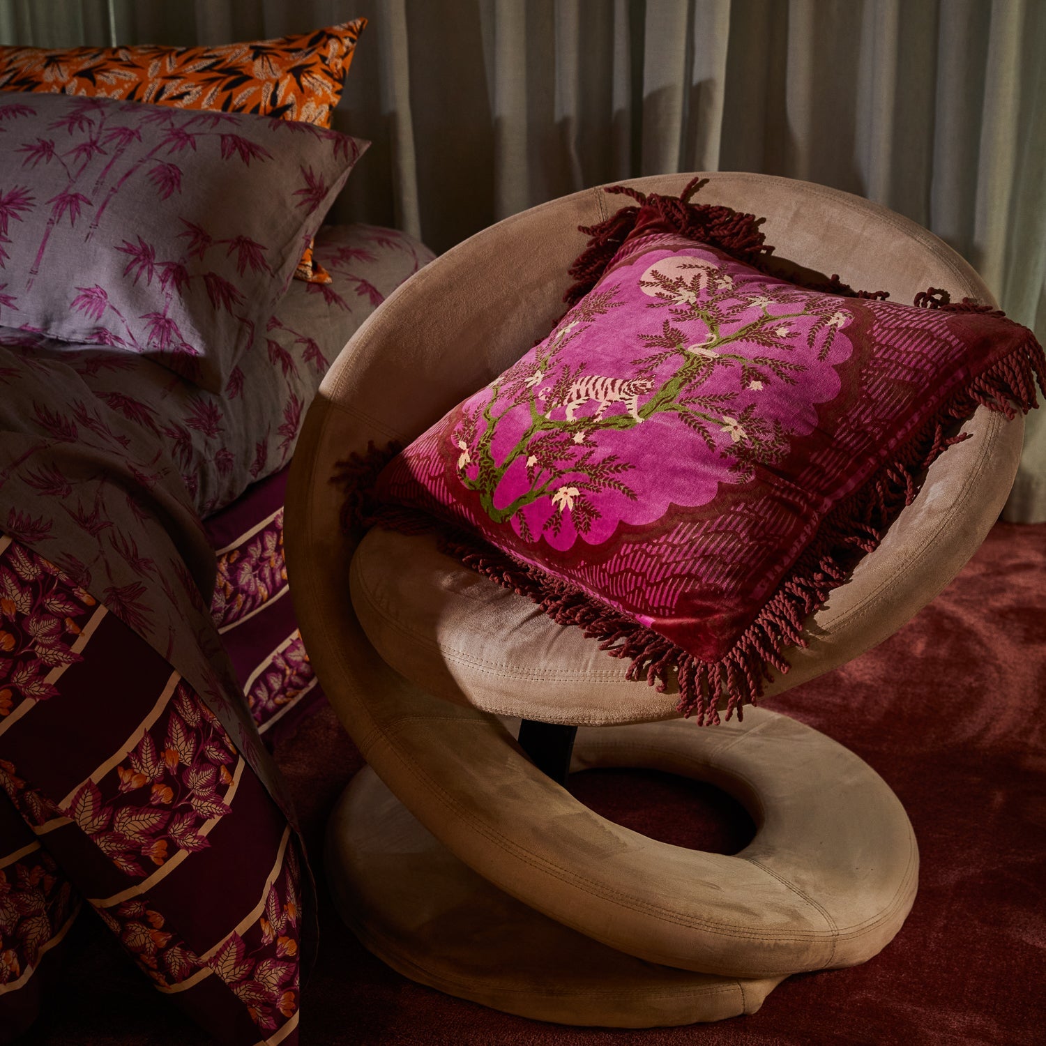 Andrea Velvet Cushion displayed on curved chair showing fringe detail and luxury velvet texture