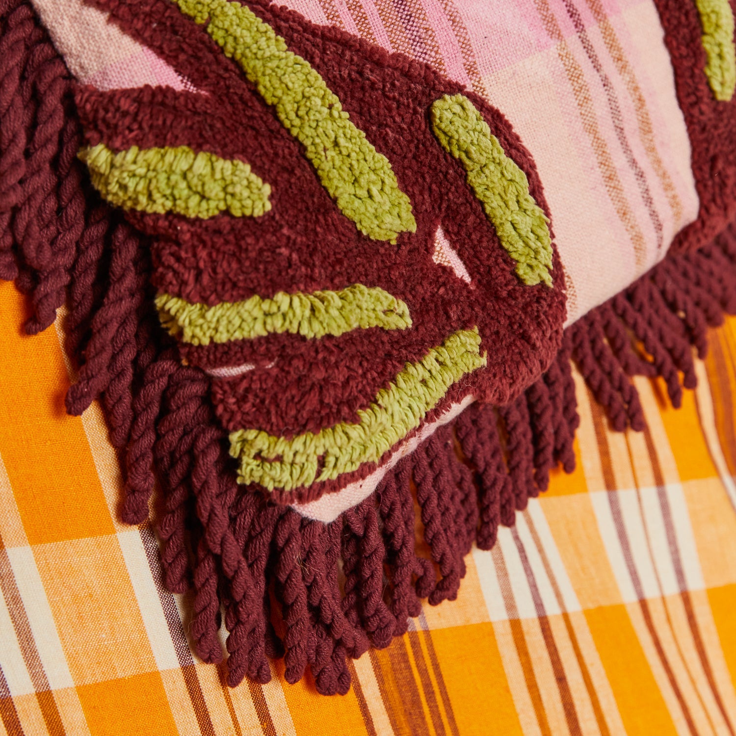Macro detail of Aneta Tufted Blanket showing geometric maze pattern with burgundy and chartreuse tufted texture