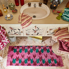 Bath room display with Arlette Bath Runner by Sage and Clare made from organic cotton with pink and green geometric pattern retro style