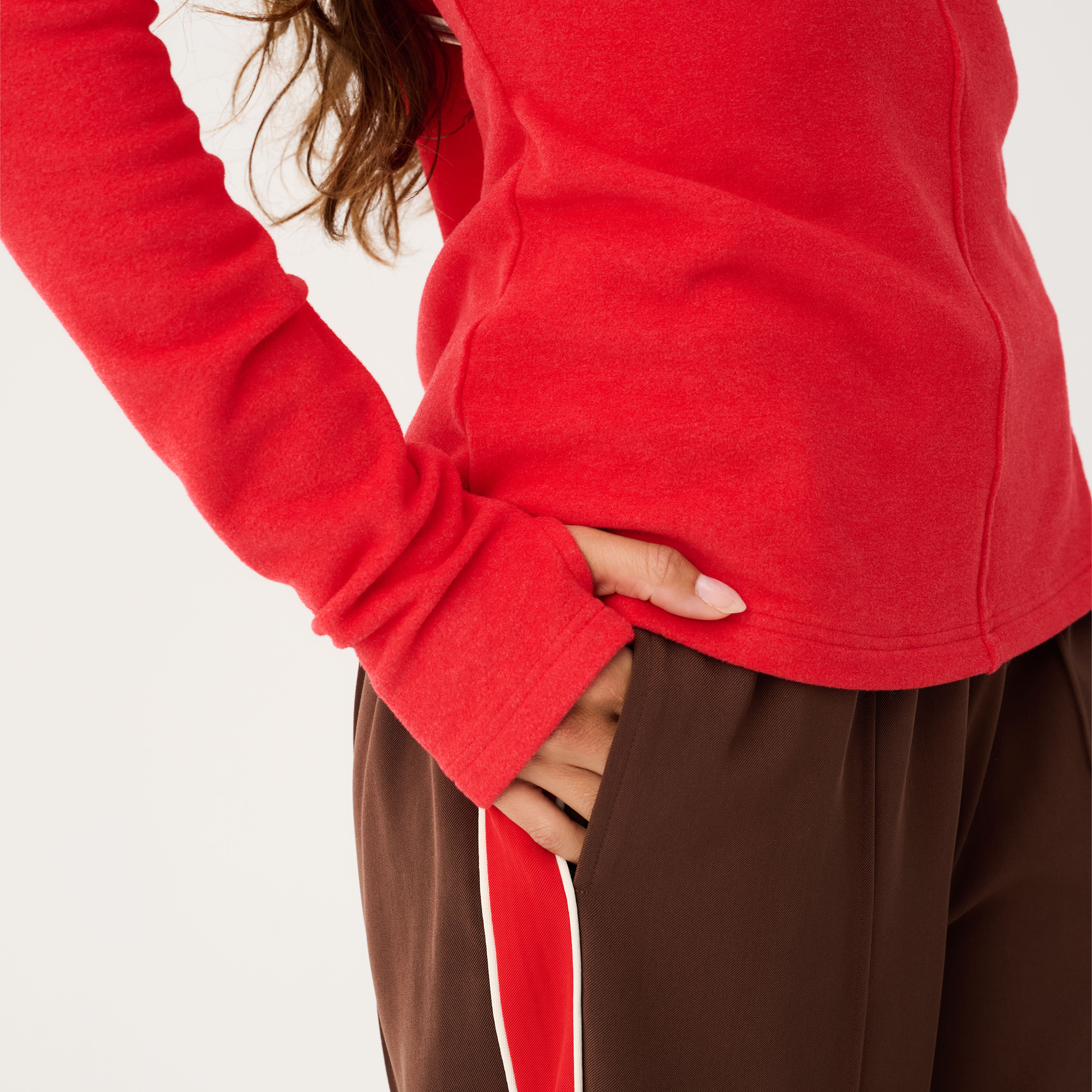 Side view of red Aspyn Top Siren showing fitted silhouette and center seam detail with long sleeves