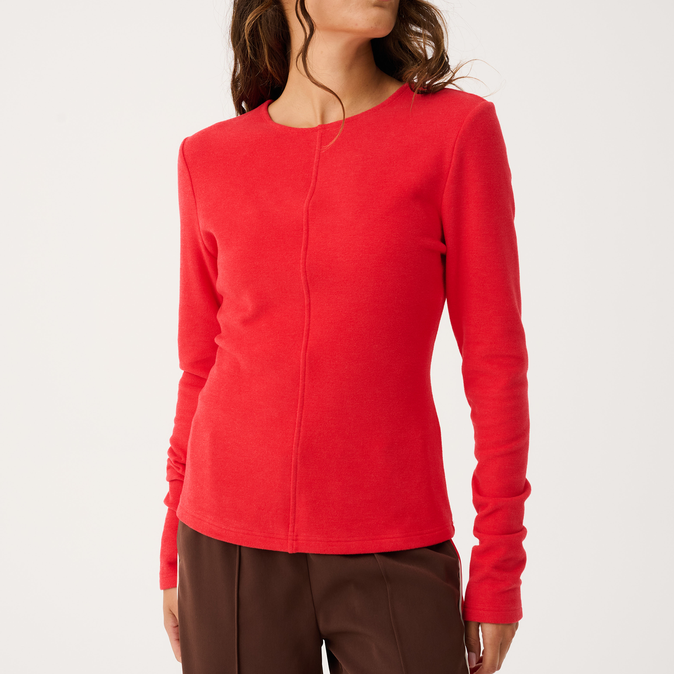 Three-quarter angle view of red Aspyn Top Siren showing fitted long sleeve design and tailored fit