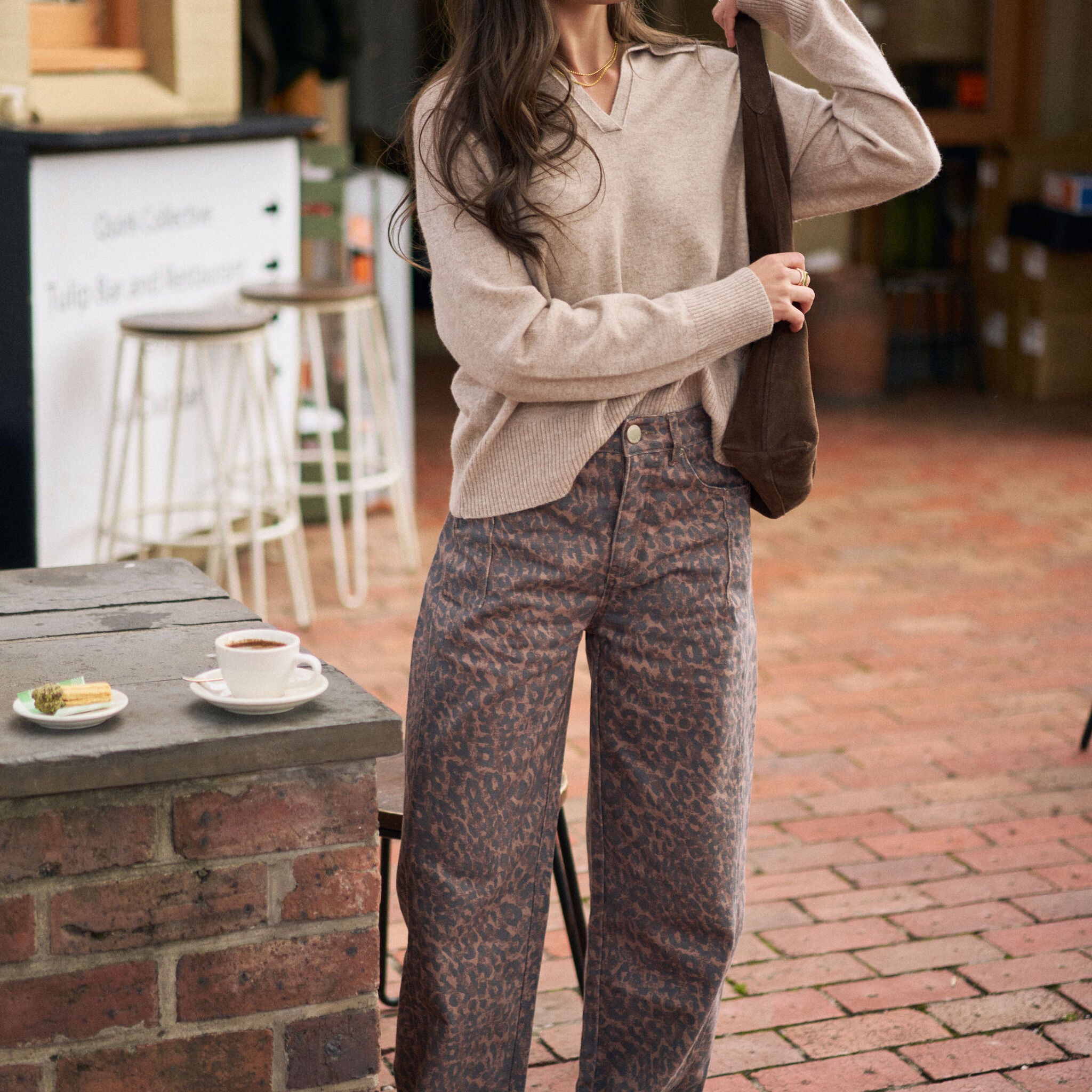 Full body shot of woman in oat marle knit pullover showing relaxed oversized fit