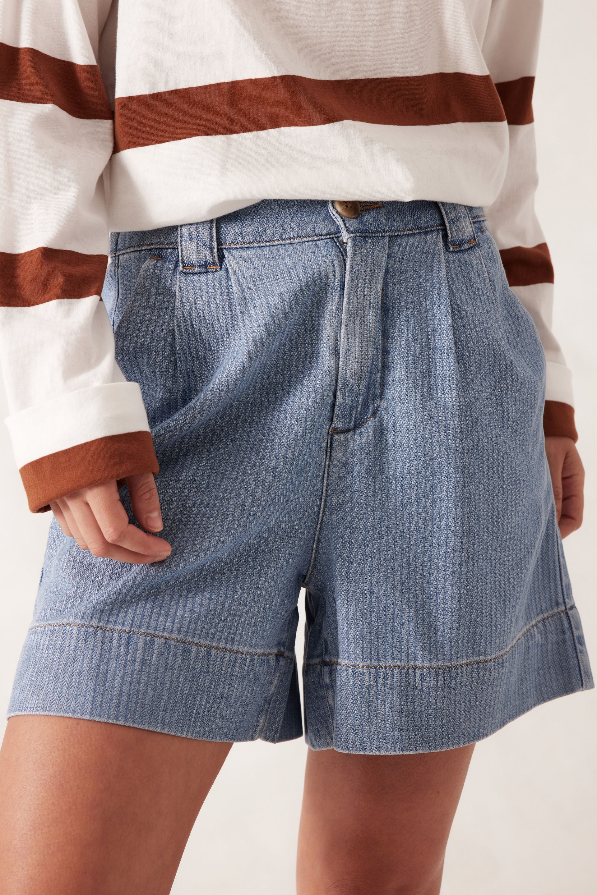 model wearing Billie Pleat Front Short by Ceres Life - light blue herringbone pattern denim shorts