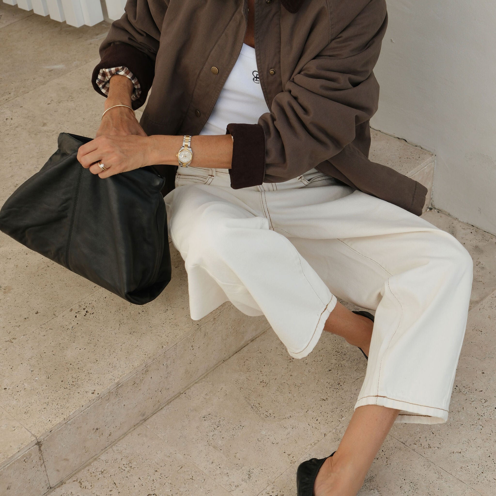Woman sitting wearing moss green barn jacket with oversized fit and corduroy trim details
