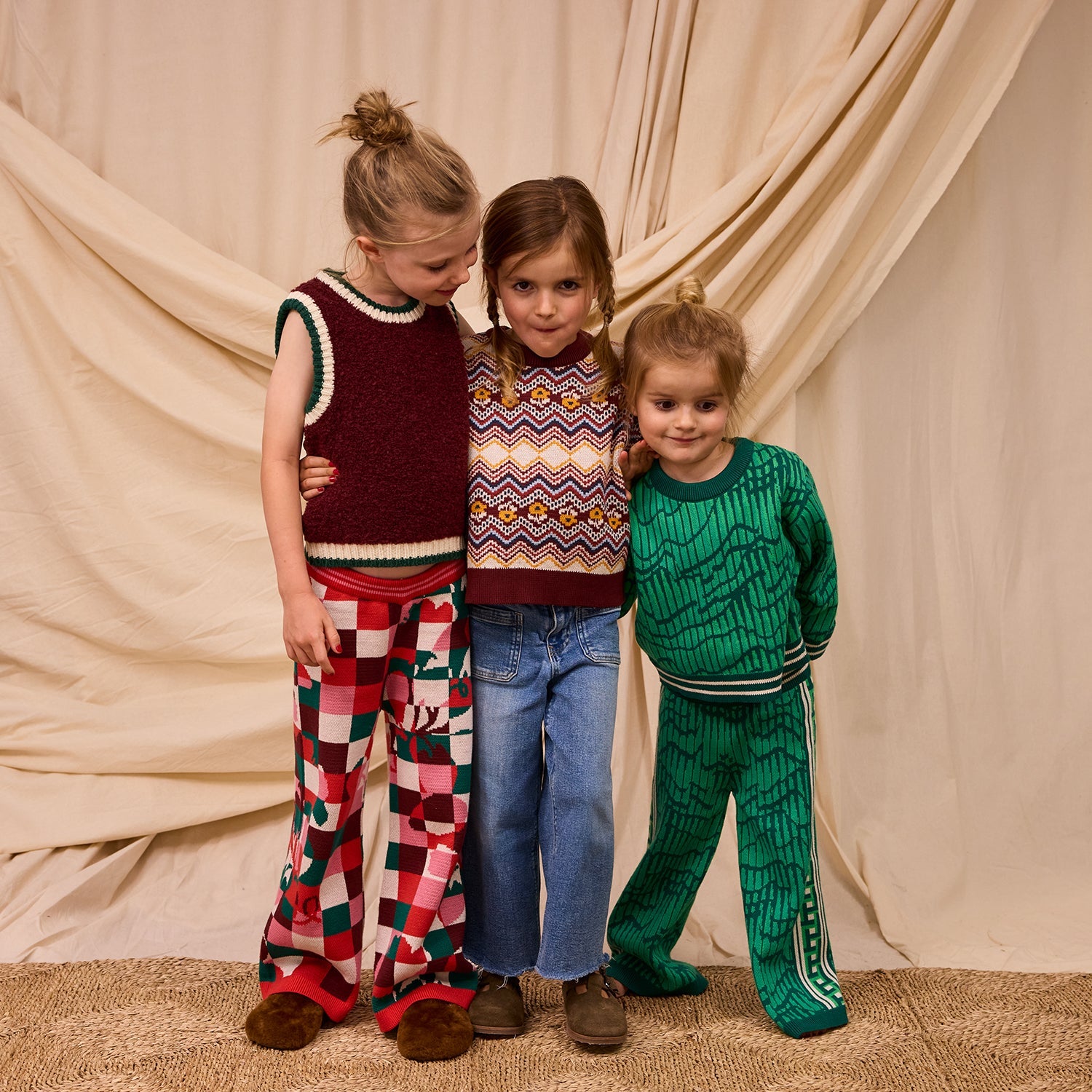 Group shot of three children with focus on checkered knit pants worn by girl on left