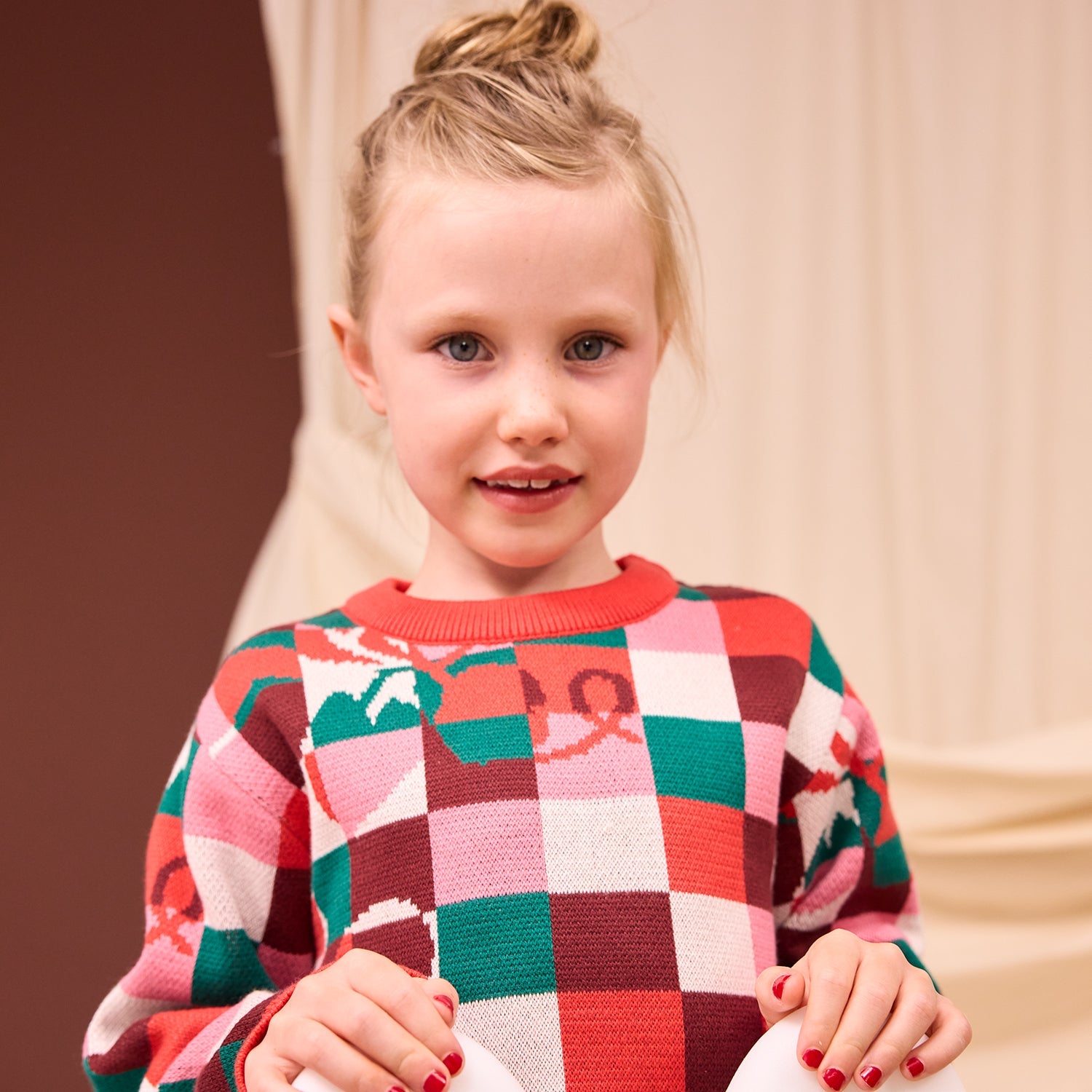 Front view of Bodhi Kids Knit Sweater in colorful checkered pattern with red ribbed crew neck