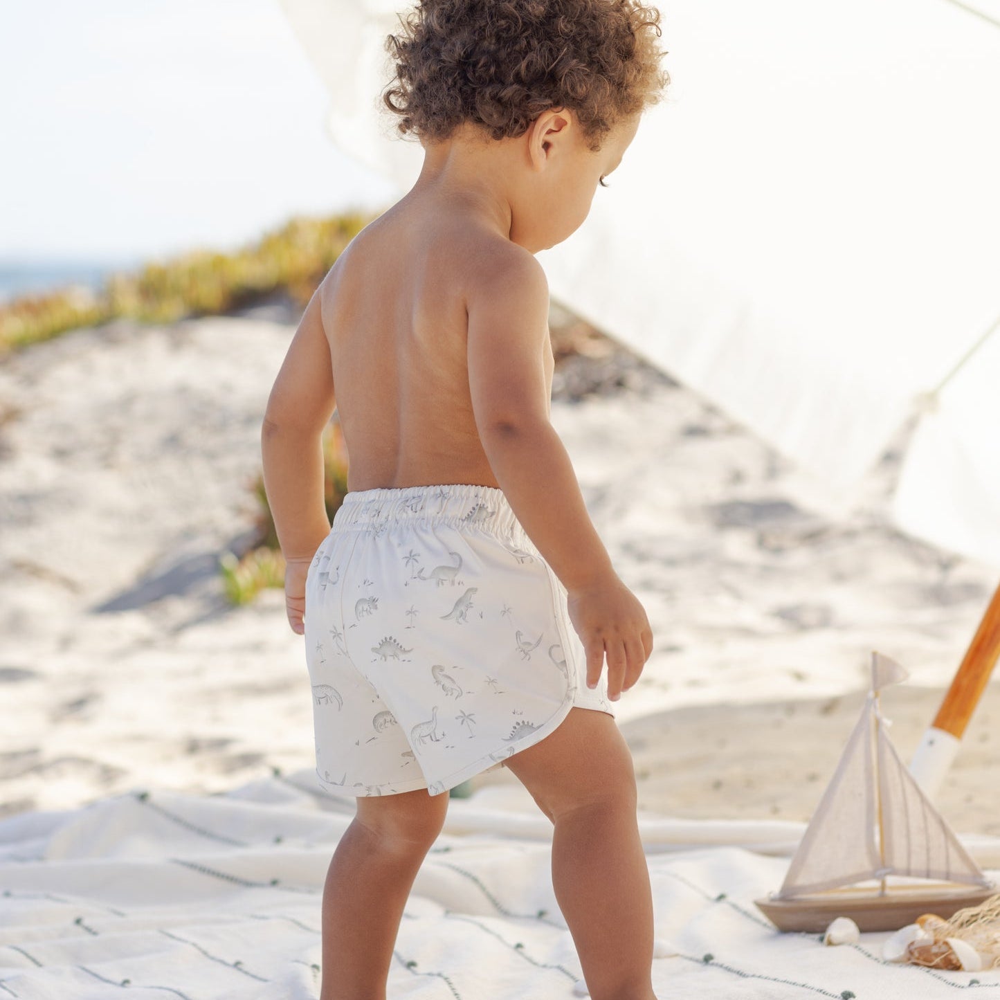 Back view of toddler wearing the Boys Swim Short Dinosaur | Quincy Mae