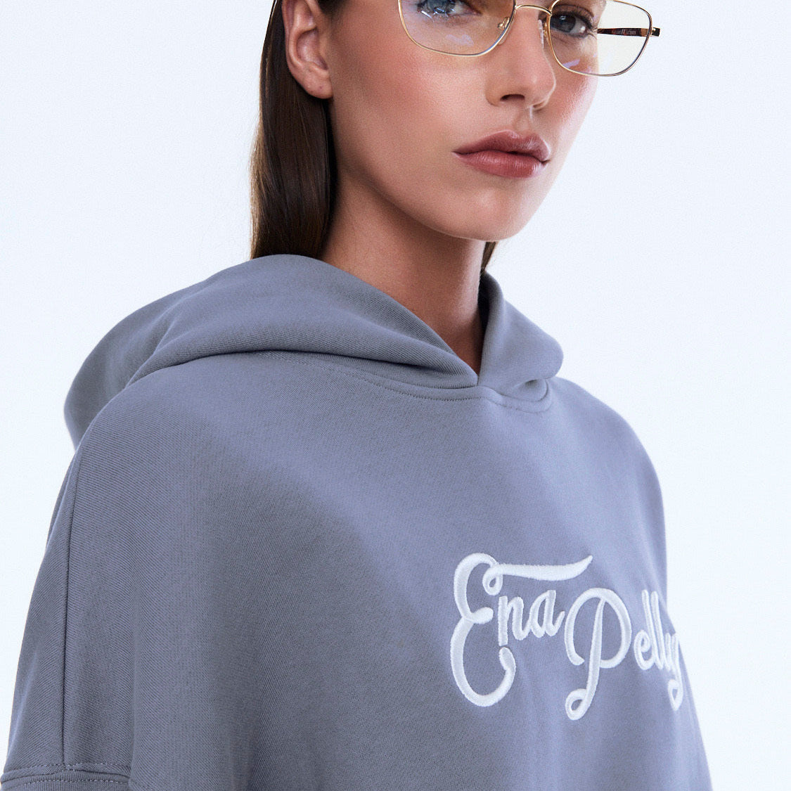 Close-up of Cassie Oversized Hoodie in gray showing white logo and hood detail