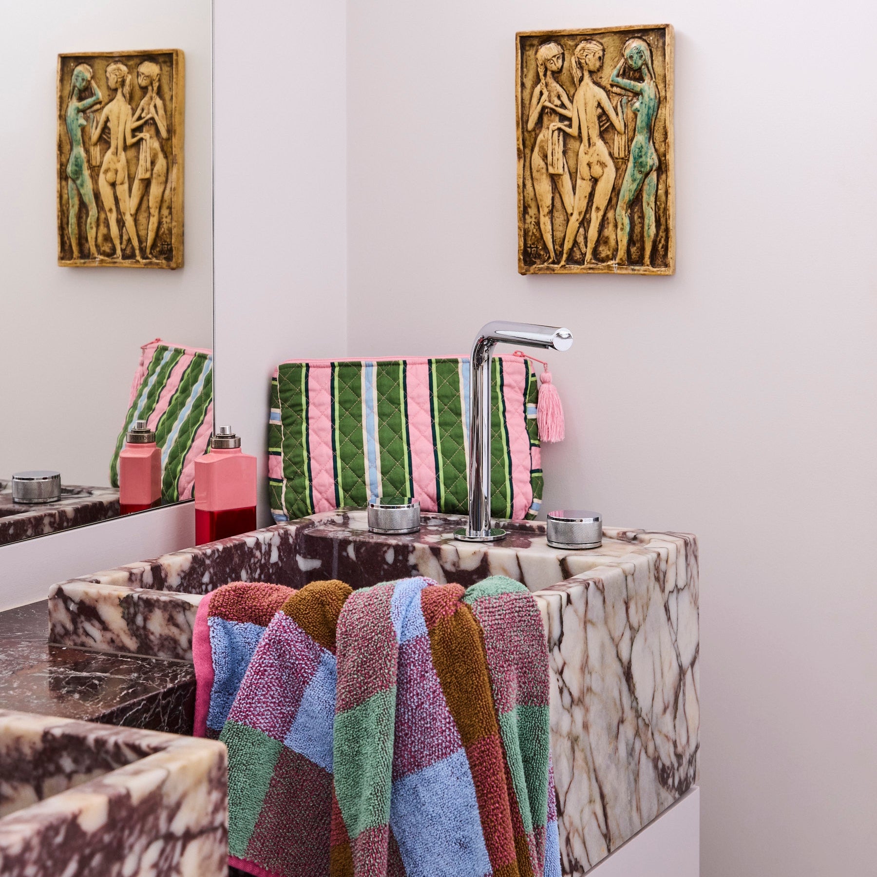 Kip & Co Cactus Stripe toiletry purse displayed on marble bathroom counter with pink tassel detail visible