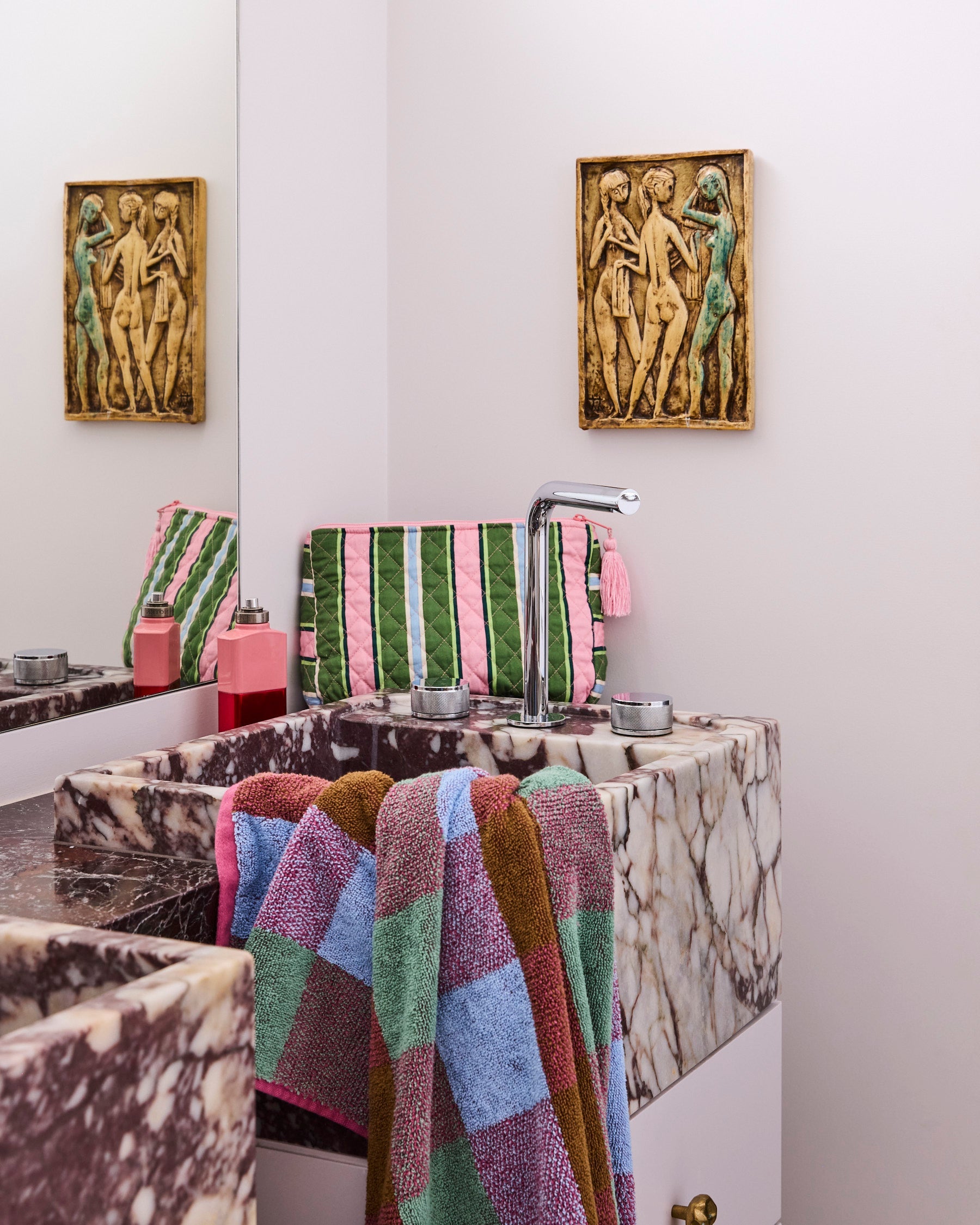 Kip & Co Cactus Stripe toiletry purse displayed on marble bathroom counter with pink tassel detail visible