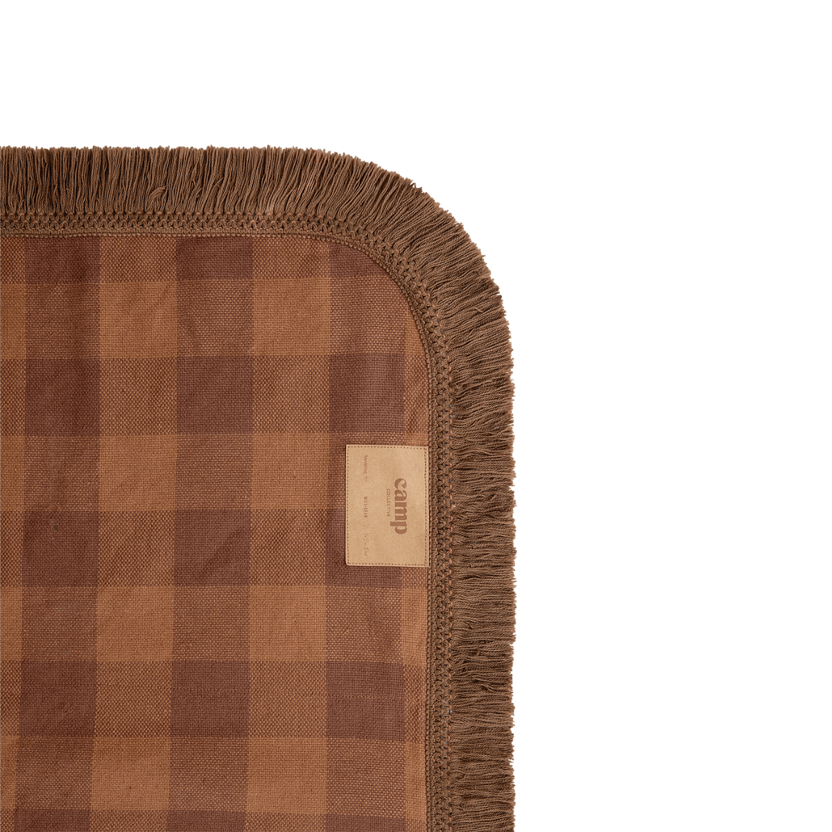 Corner detail of Camp Picnic Rug showing brown fringe trim and hemp gingham fabric texture