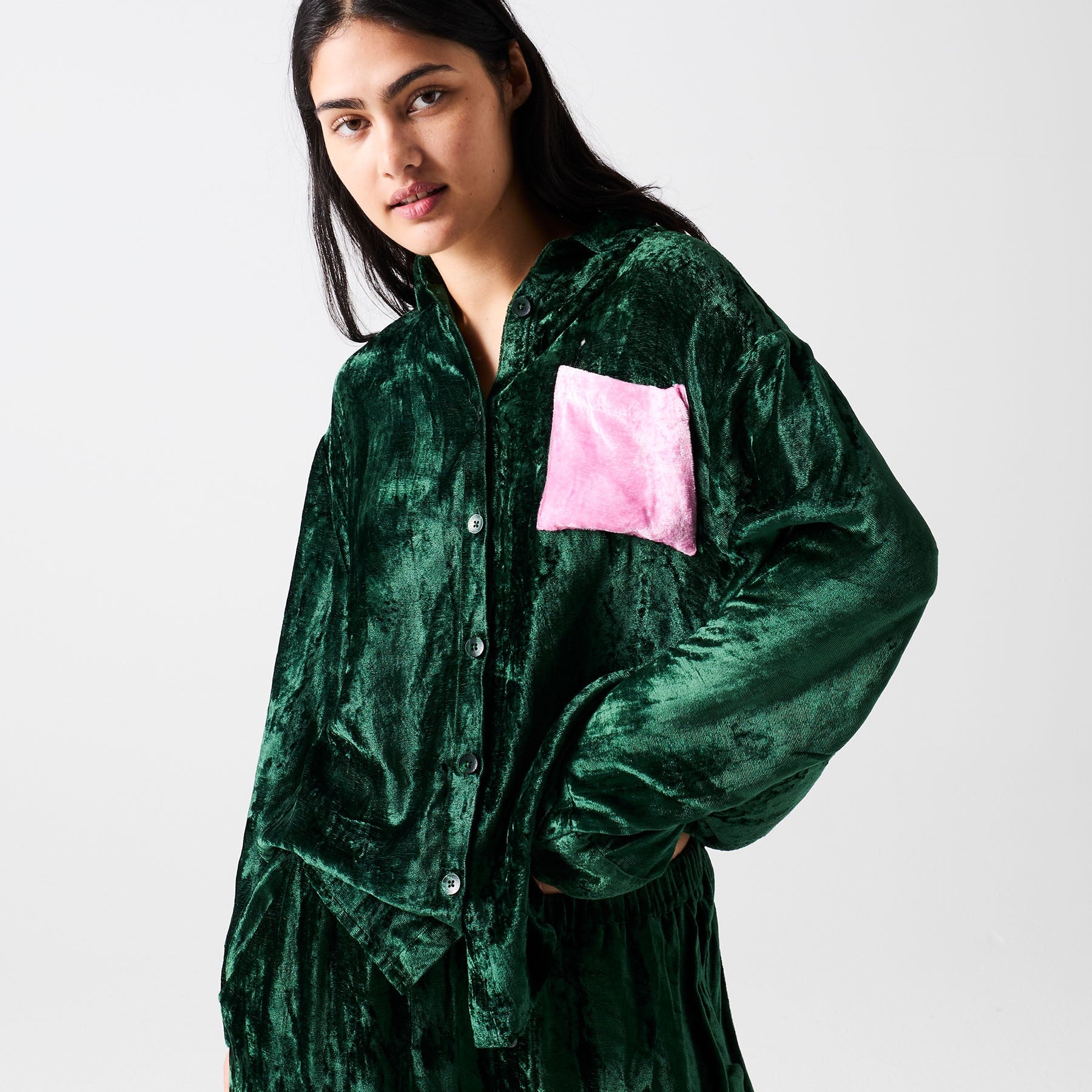 Three quarter view of Candy Pine velvet pajama shirt showing pink chest pocket and button closure