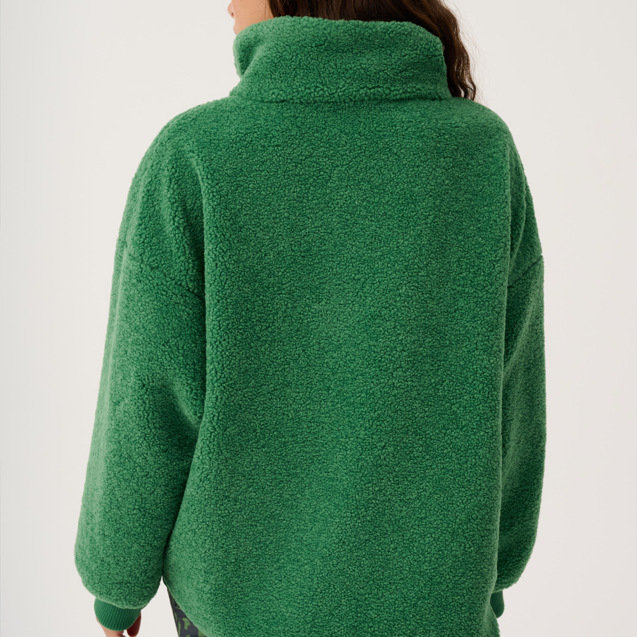 Back view of green Celeste Pullover displaying high collar and oversized silhouette