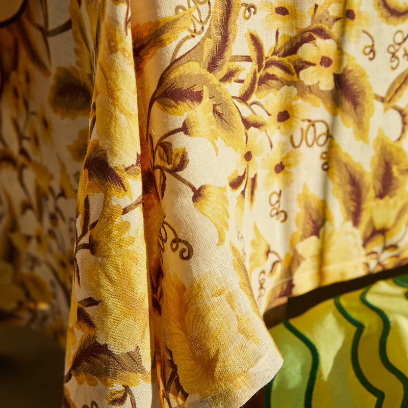Close-up of a floral patterned fabric with yellow and brown colors.