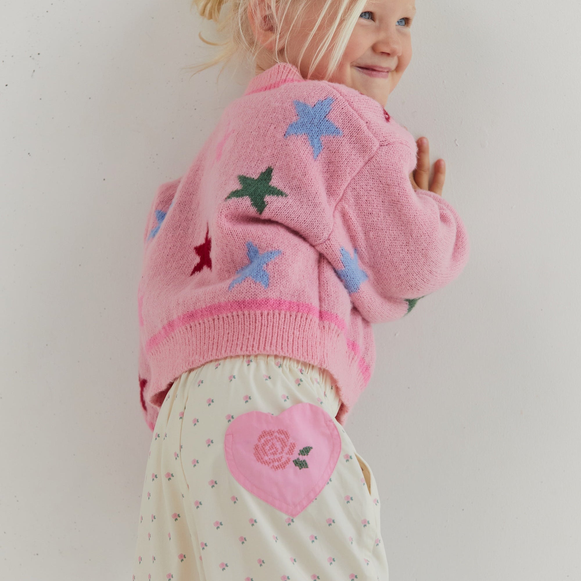 Side view of Cleo Pant showing pink heart patch and small rose print on cream fabric
