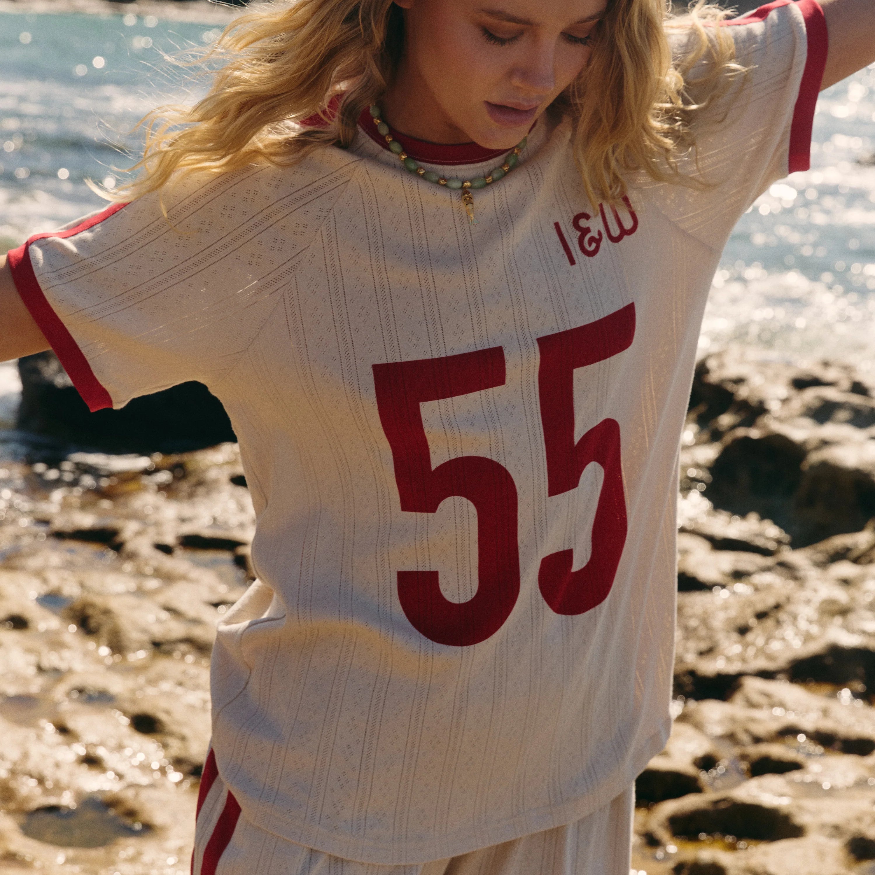 lady wearing organic cotton pointelle fabric tee in cream with red "55" print across the front