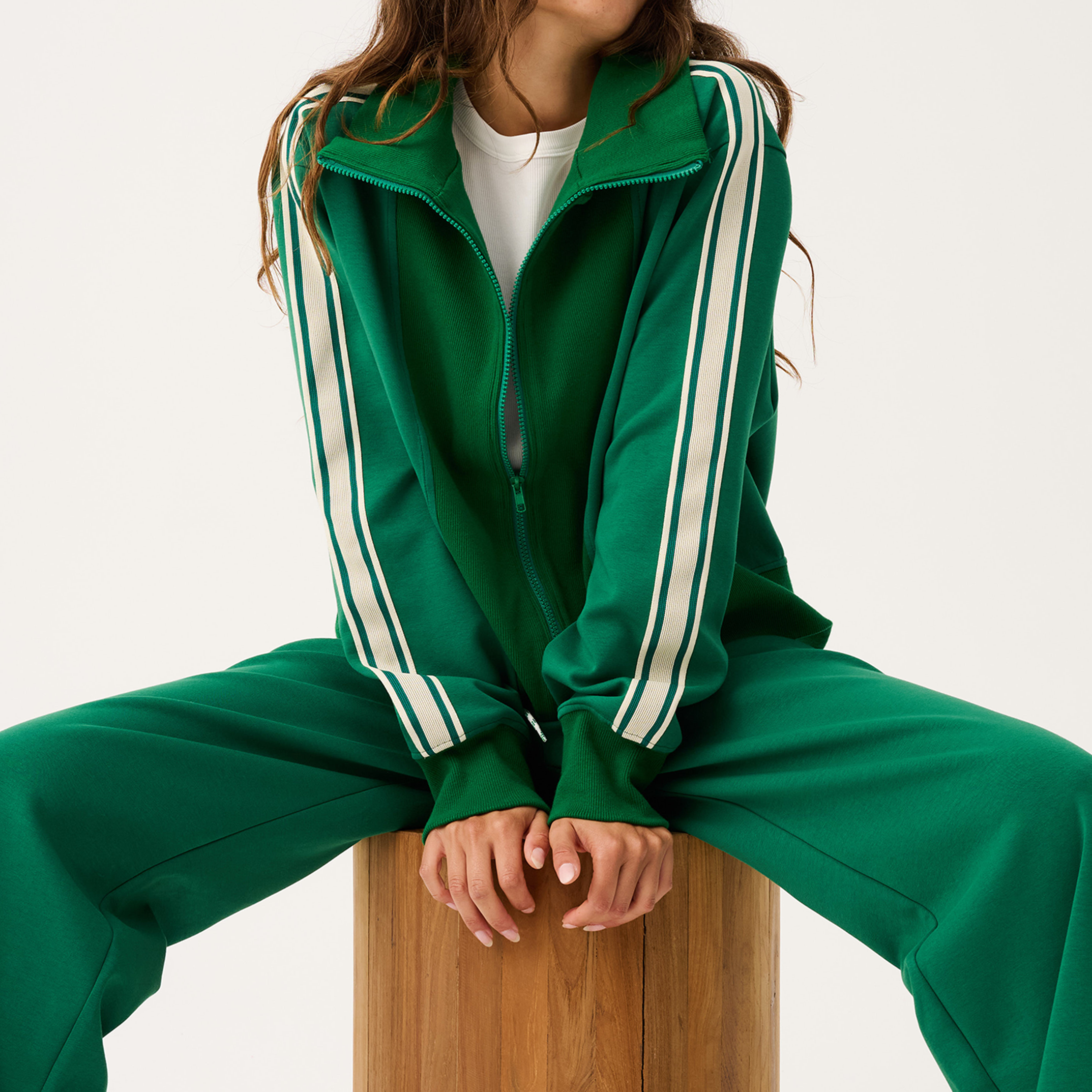 Full tracksuit view of green Corey Zip Through Sweater worn open over white tee with matching pants