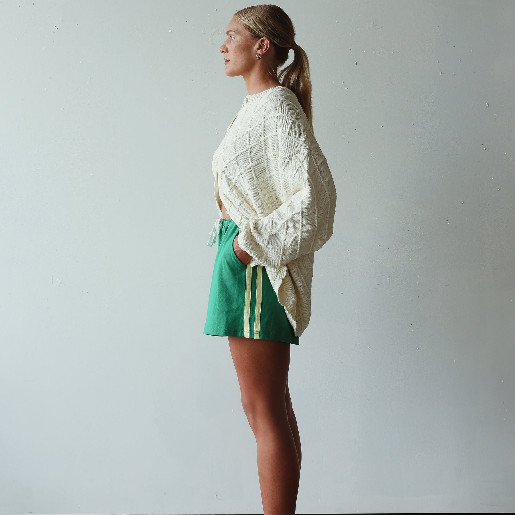side profile of model wearing Crochet Knit Cardigan - cream by By Billie