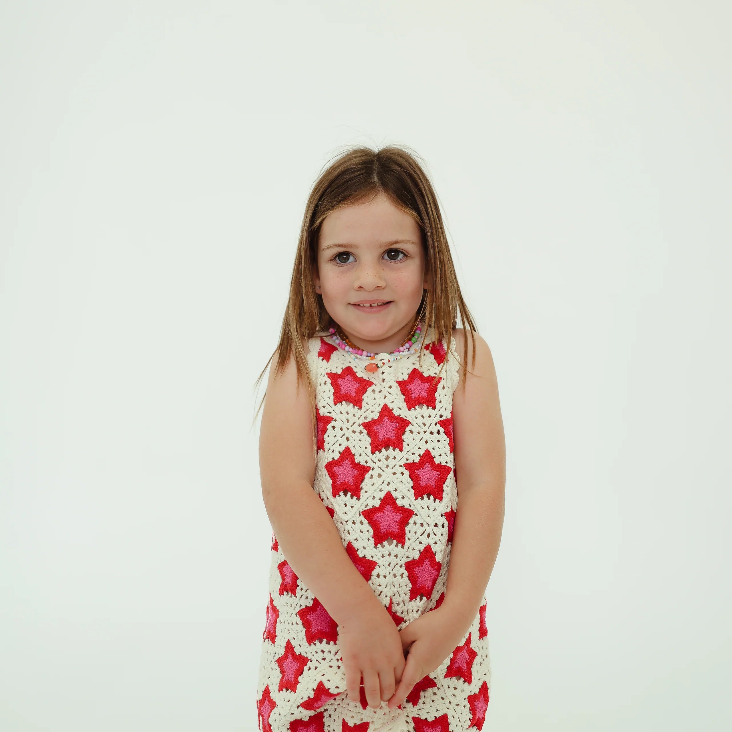 girl wearing cotton crochet dress with pink and red stars