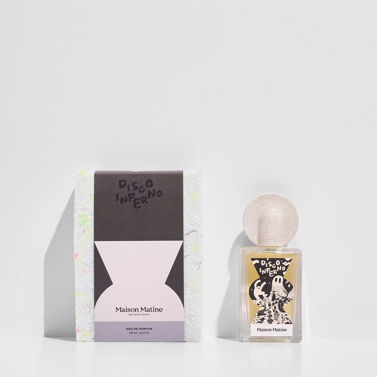 Disco Inferno perfume and packaging box side by side showing black and pink design with speckled cap