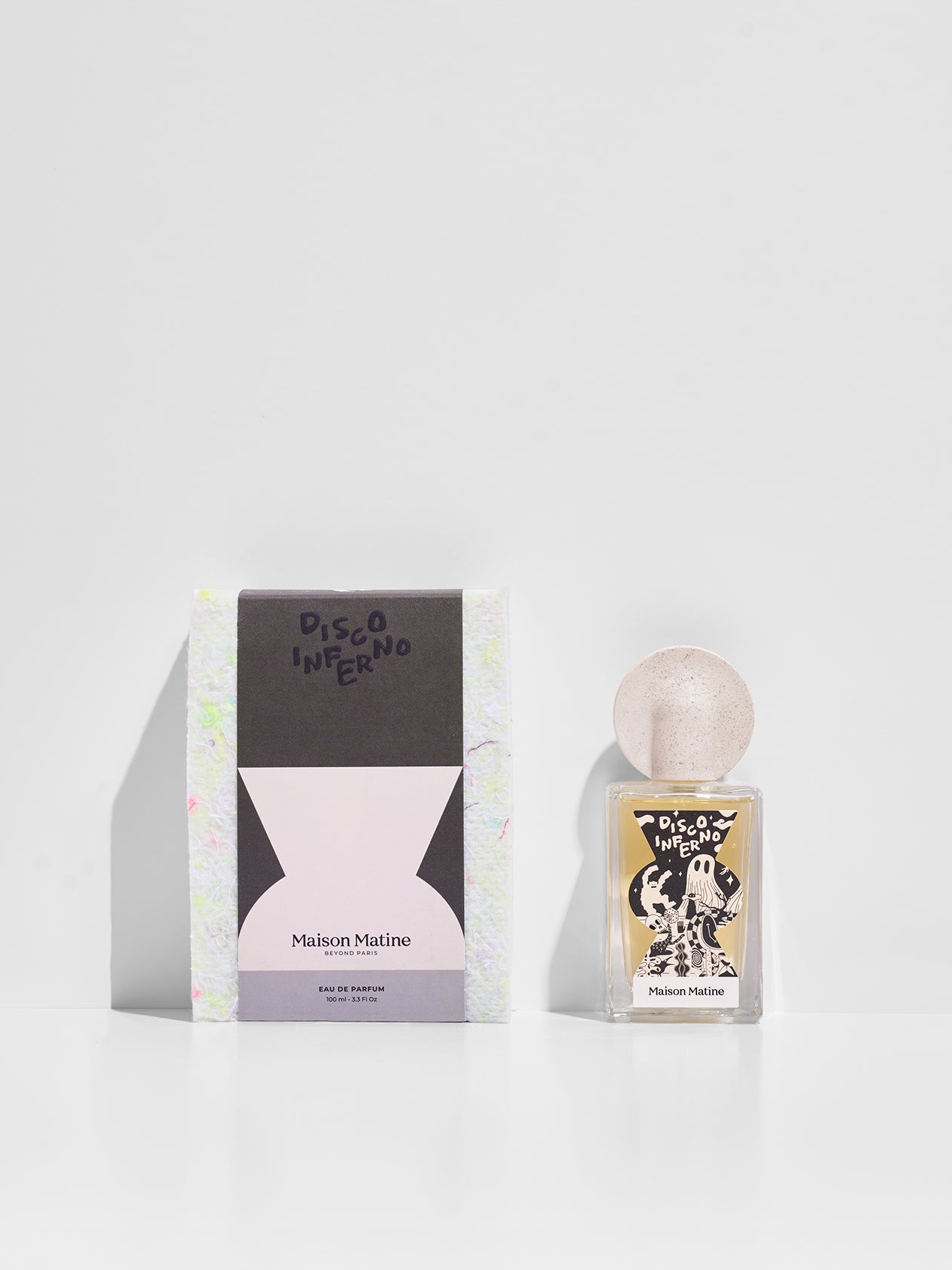 Disco Inferno perfume and packaging box side by side showing black and pink design with speckled cap