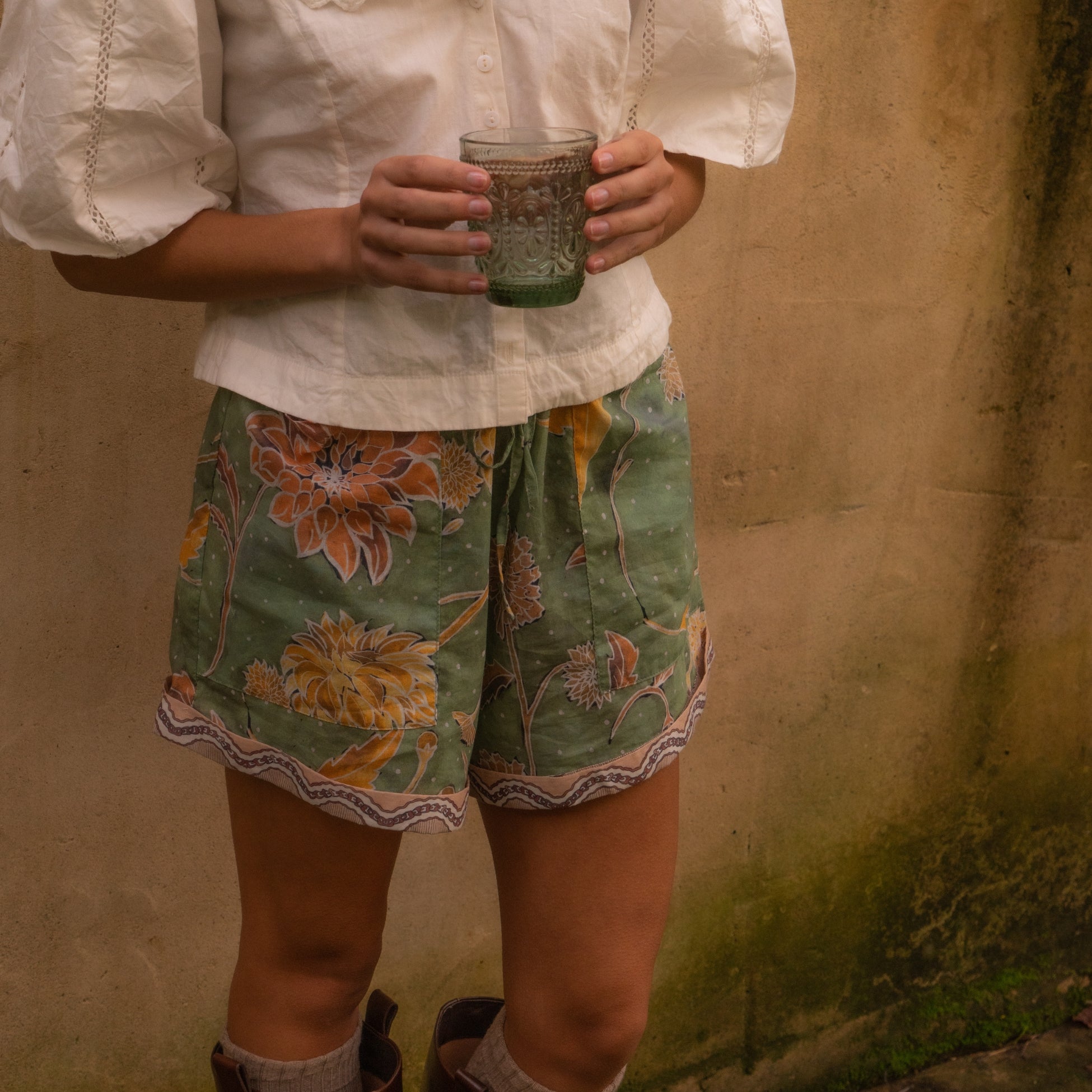 Dahlia Shorts moss green showing relaxed fit and hand-painted floral print perfect for warm days