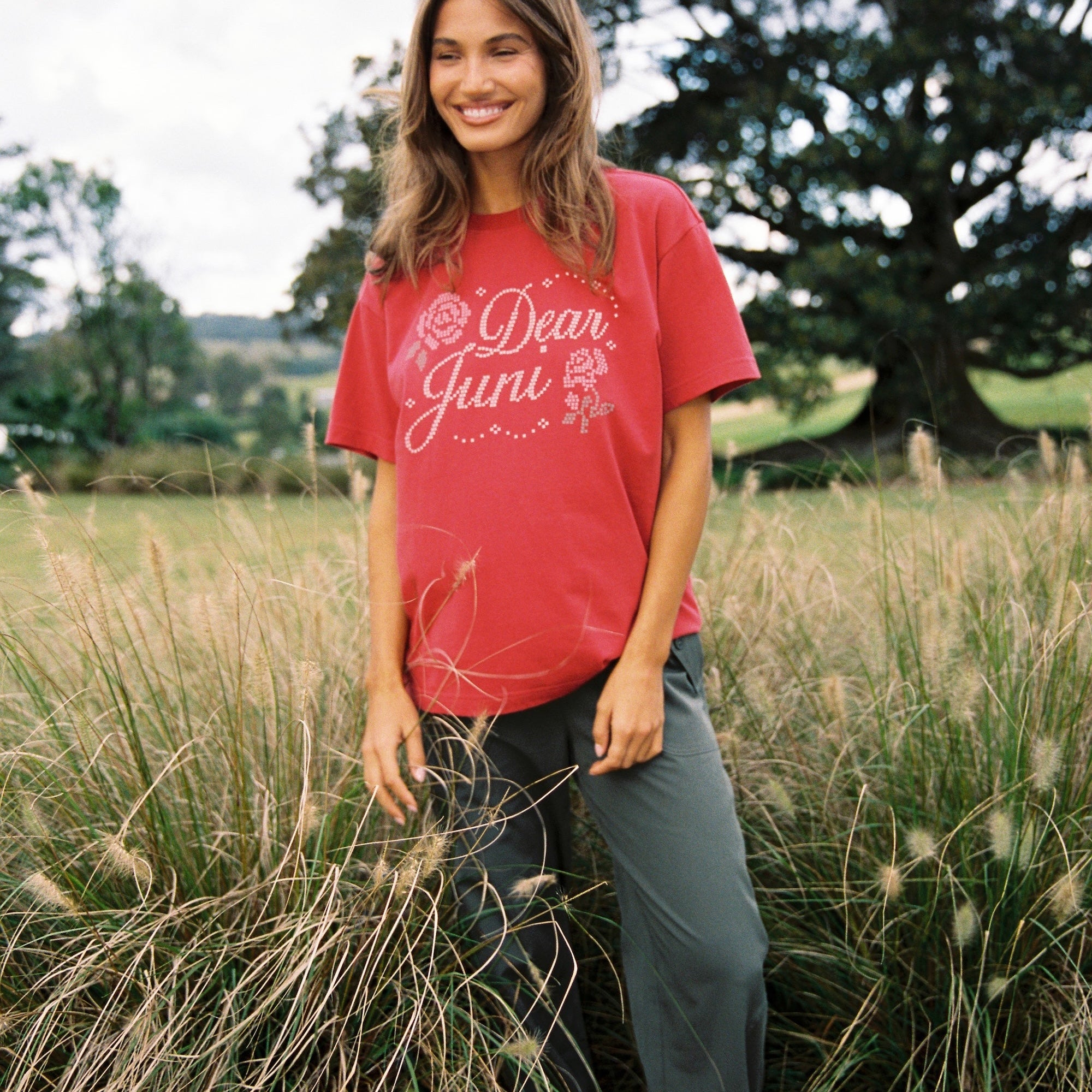 Front view of red Dear Juni Tee showing rhinestone Dear Juni text and rose graphics in chilli shade
