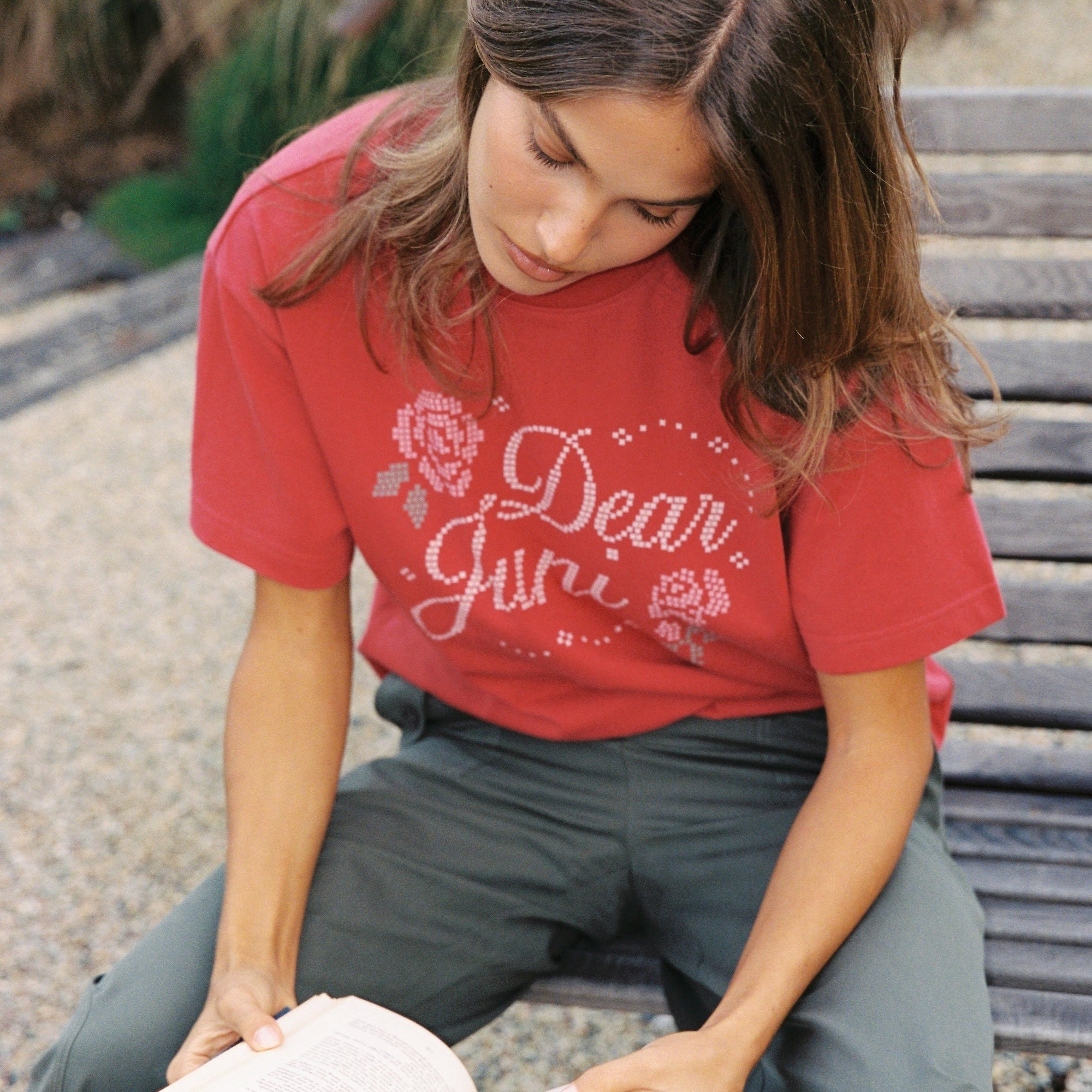 Close-up view of red Dear Juni Tee featuring white rhinestone Dear Juni text and decorative elements