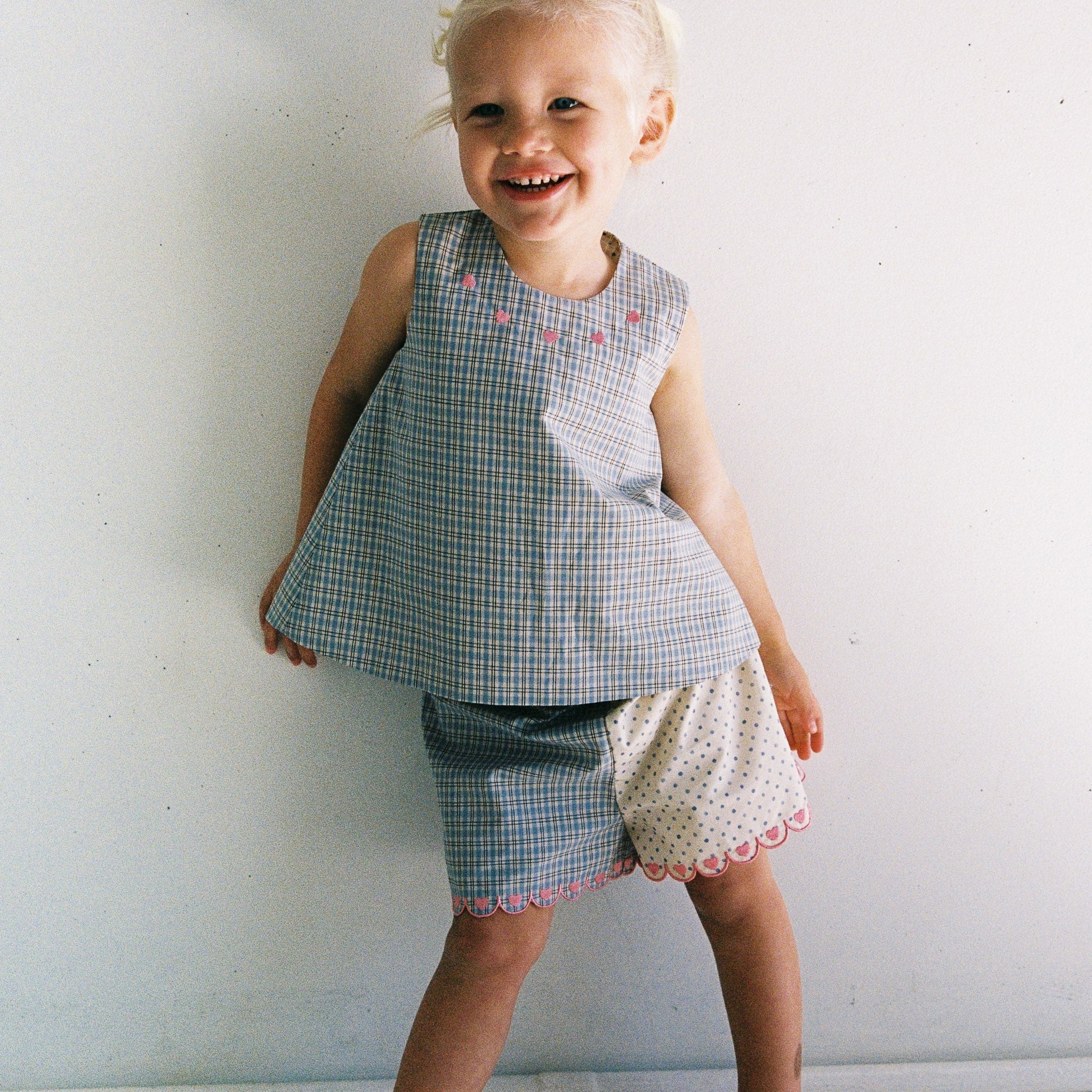 girl wearing adorable blue check and polka dot top with pink embroidery