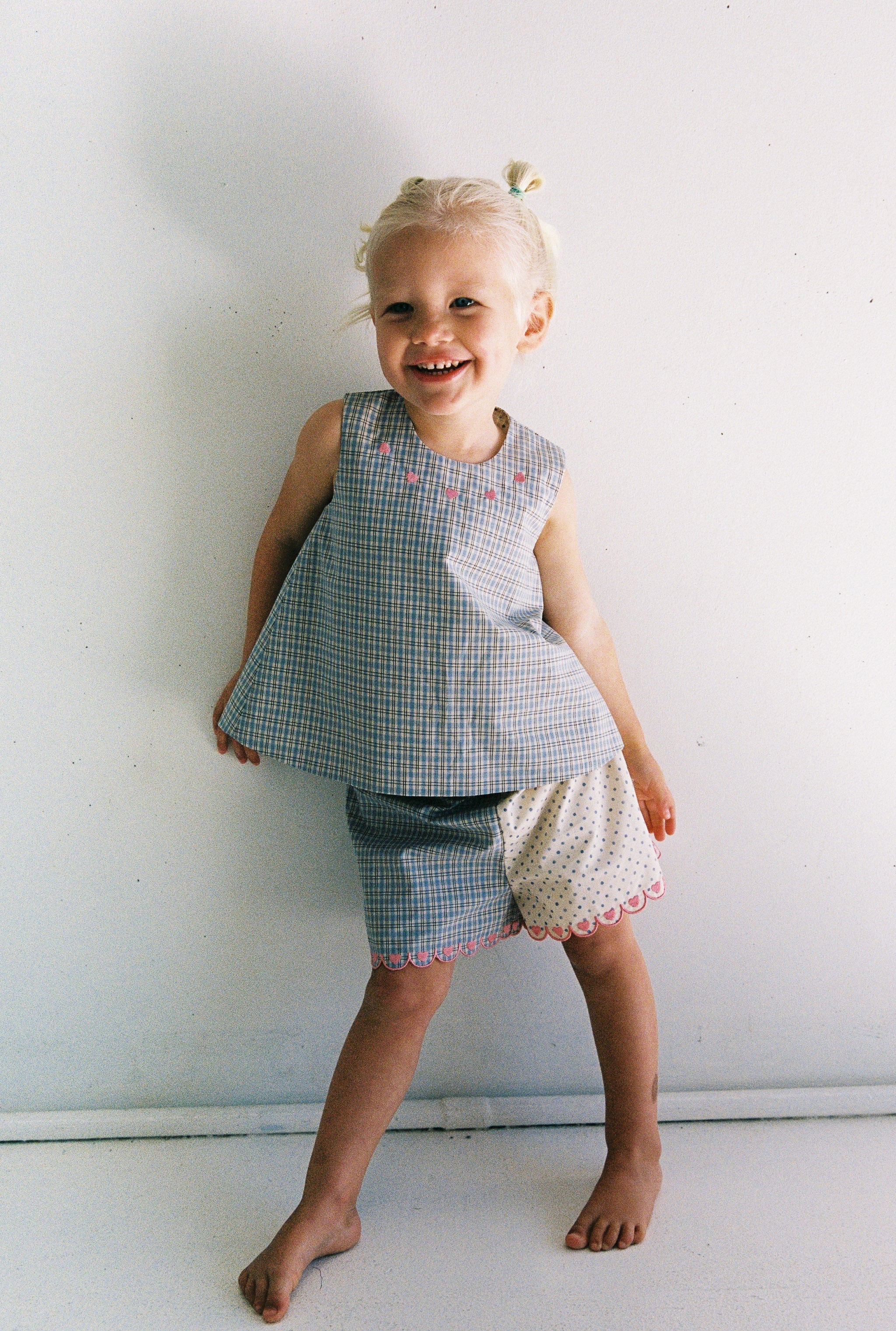 girl wearing adorable blue check and polka dot top with pink embroidery