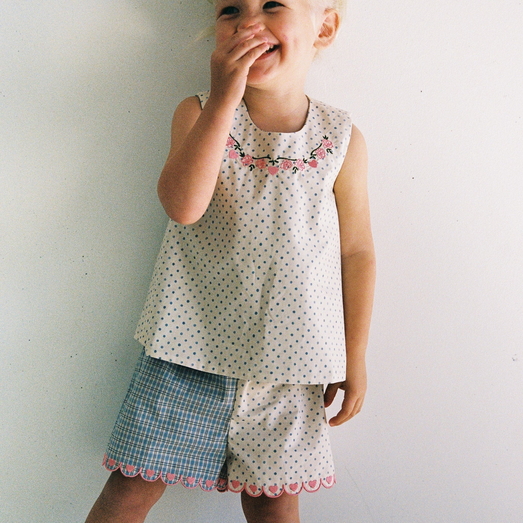 girl wearing cotton top with pink embroidery