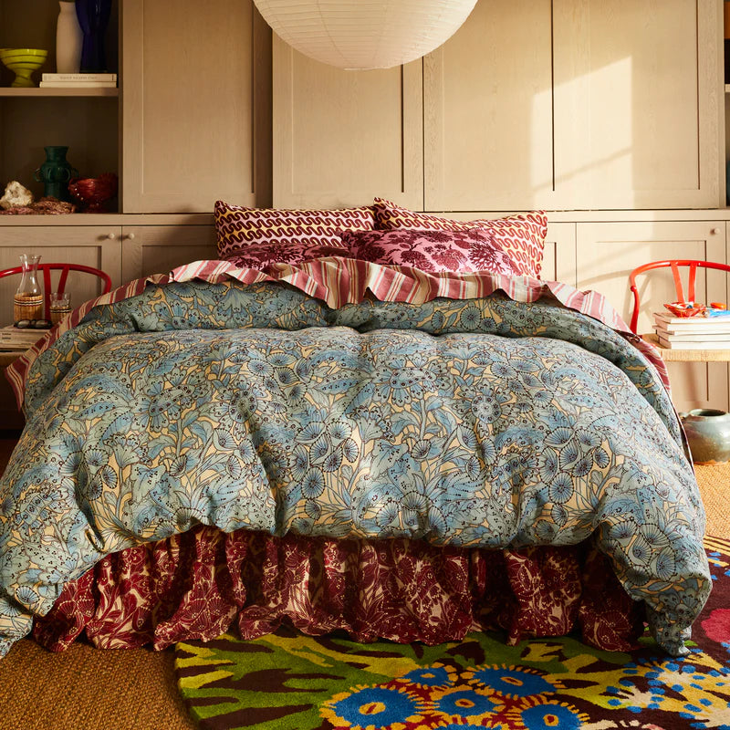 Bed with floral bedding in a bedroom setting by Sage & Clare