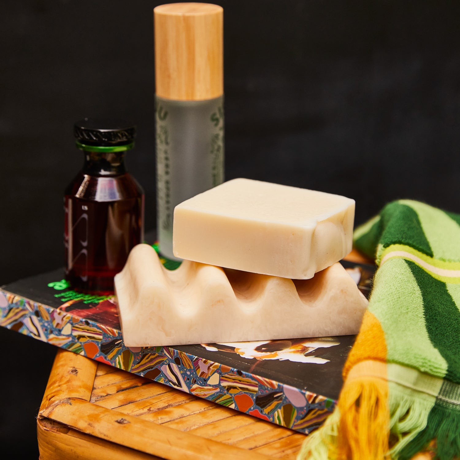 Pearl wave soap dish topped with a bar of soap, styled on a bamboo tray with bathroom accessories