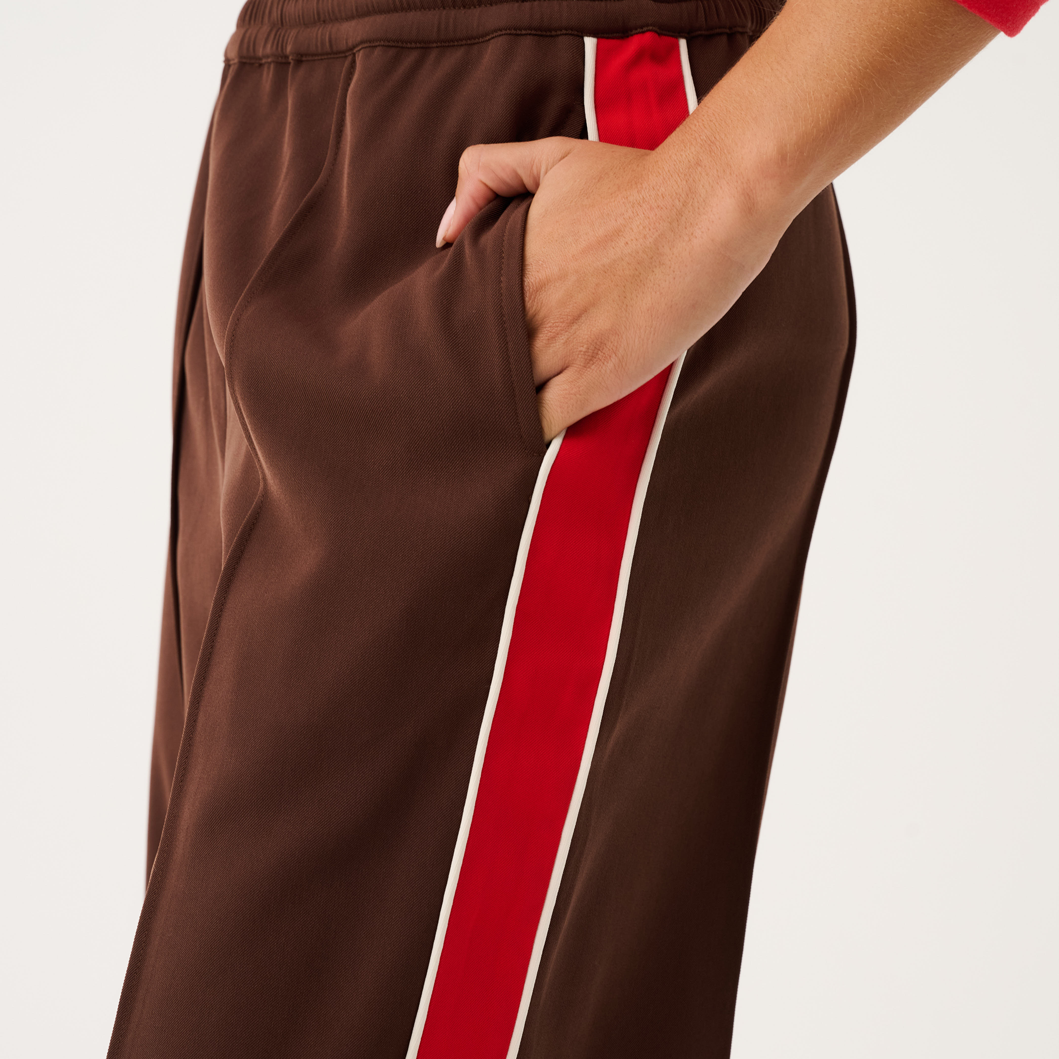 Close-up of Dusty Pant pocket detail showing elastic waistband and red stripe running along side seam