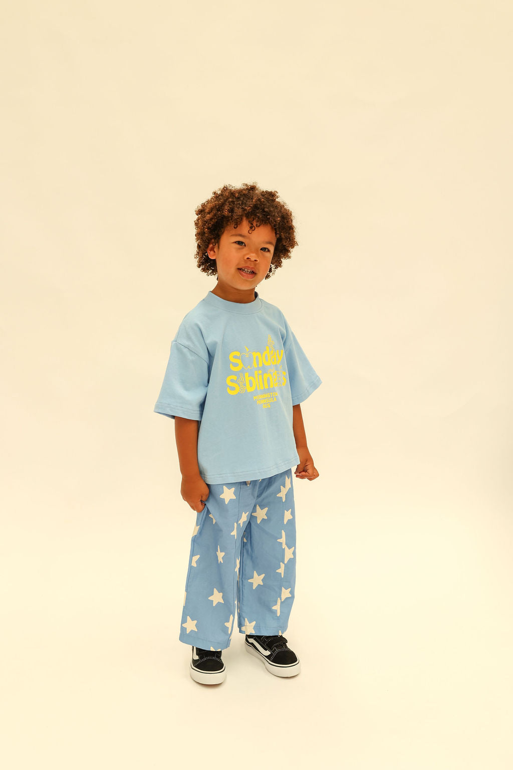 Standing pose showing Dusty Star Pants wide leg silhouette and star print in cobalt blue
