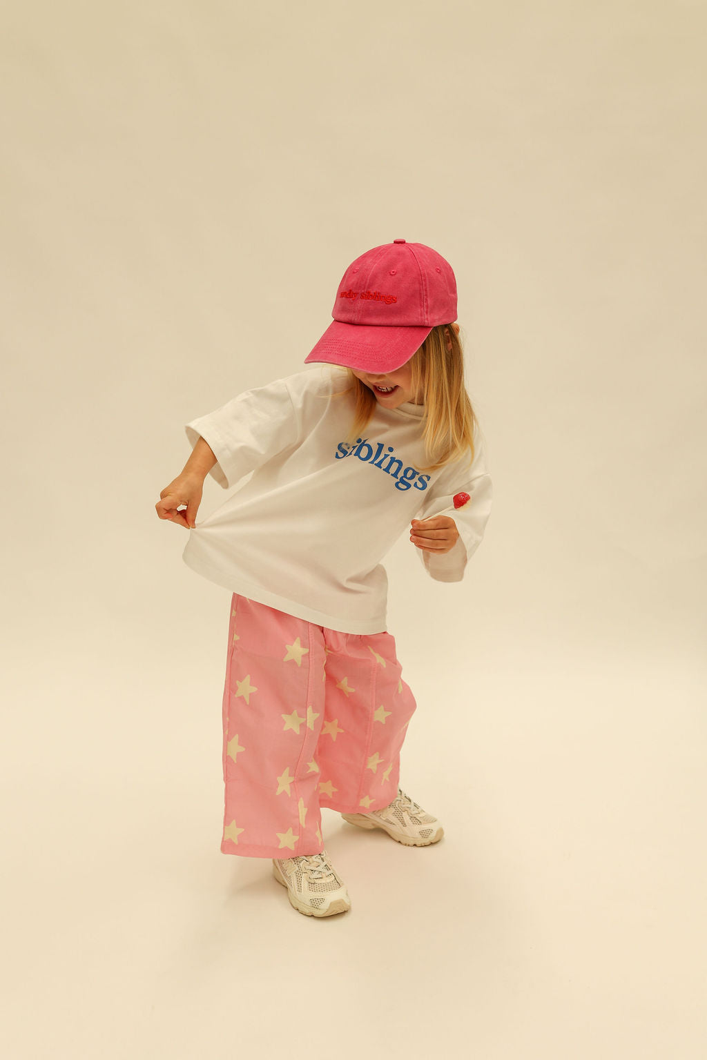 Side view of Dusty Star Pants displaying relaxed fit and yellow star print on pink fabric