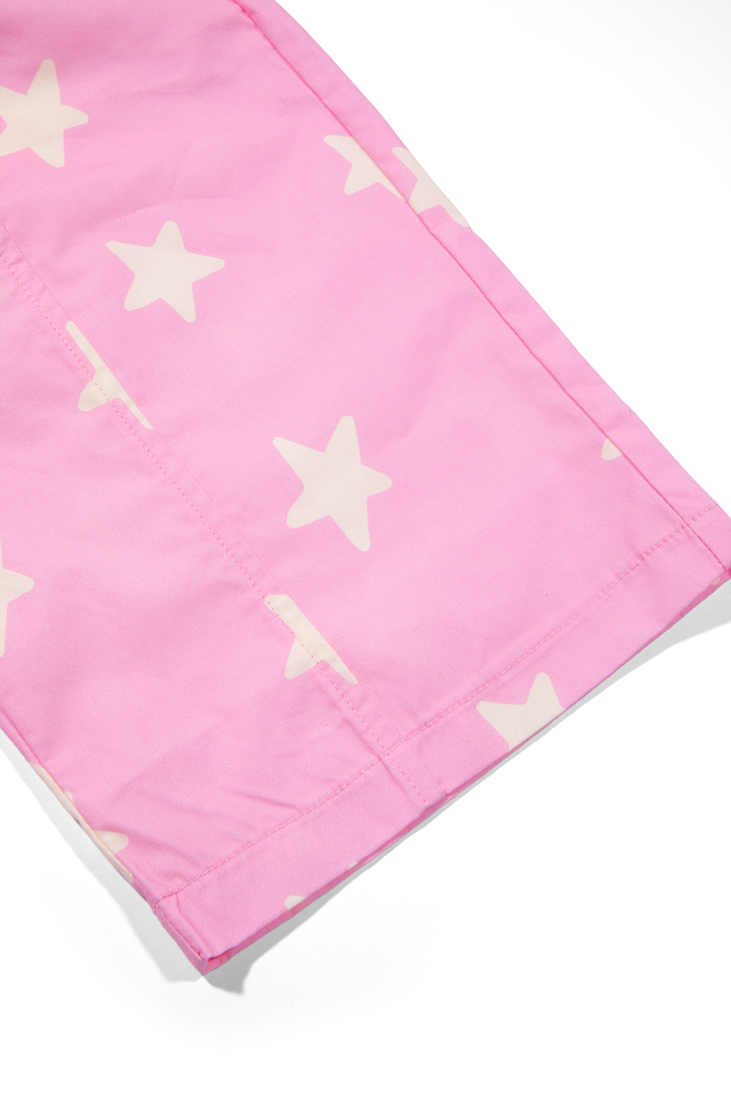Side profile view of pink Dusty Star Pants with yellow star pattern in casual styling