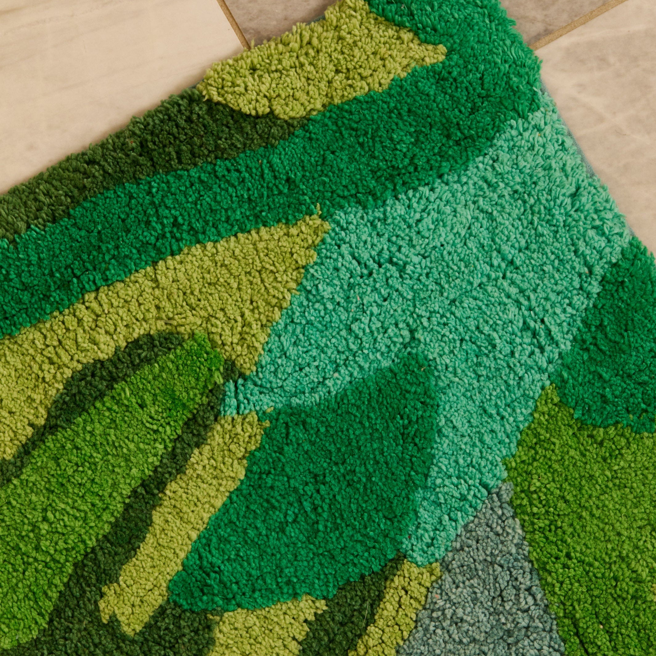 Corner detail of Dutch Floral Green Bath Mat showing hand tufted cotton pile and color variations