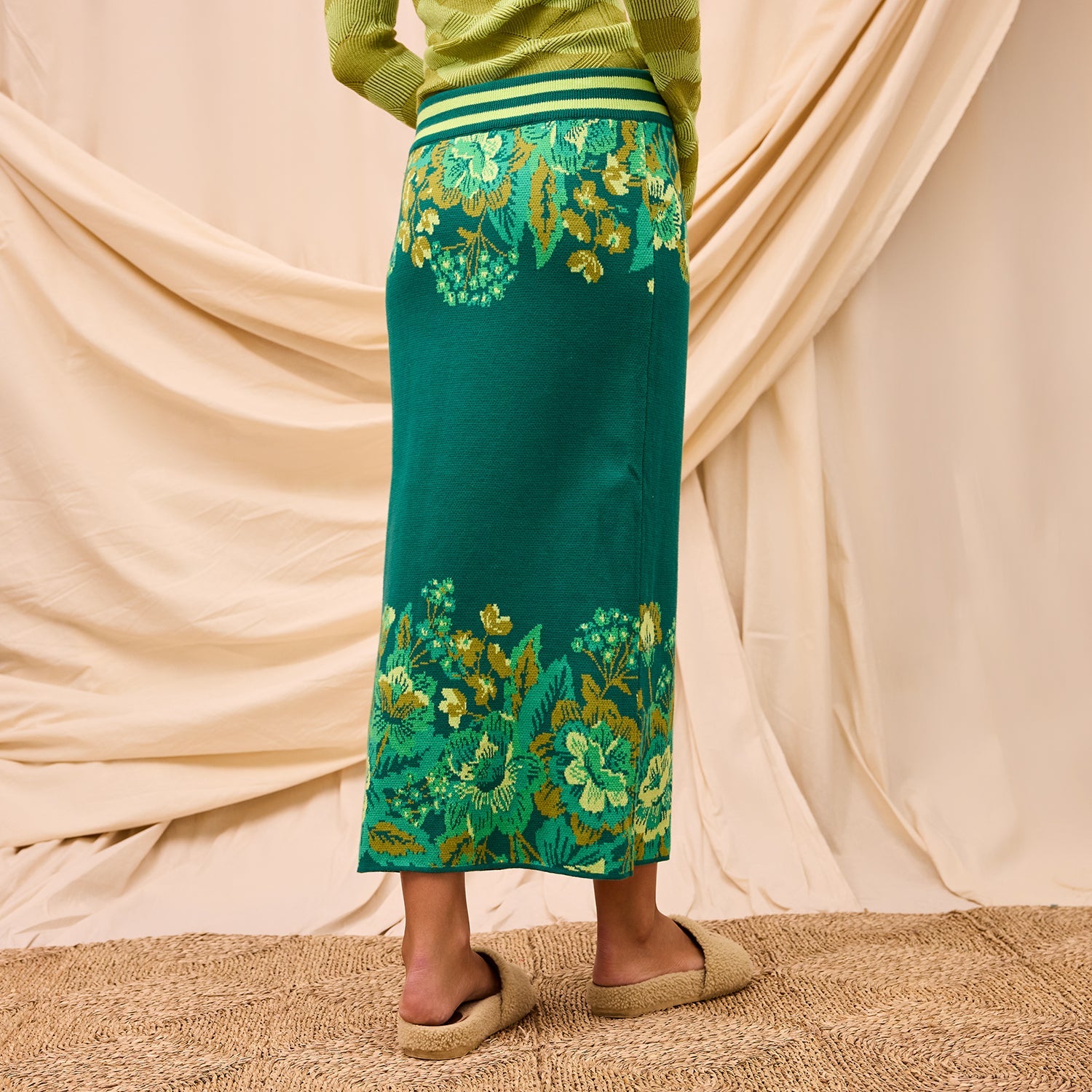 Back view of Eliza Knit Maxi Skirt displaying green floral motif and maxi length styling