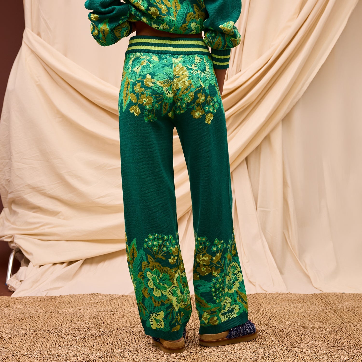 Back view of Sage & Clare Eliza Knit Pants showing full length silhouette and floral pattern on cream background